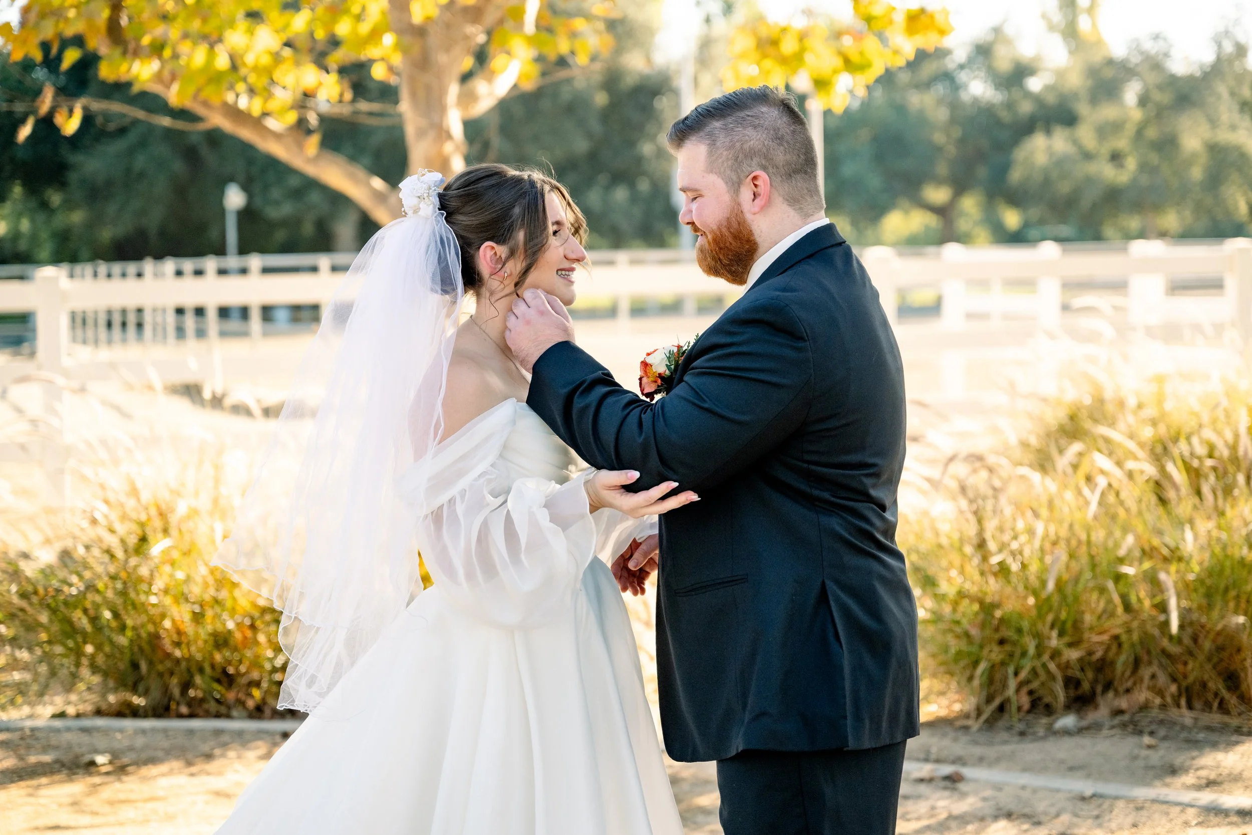 Groom cradling the bride's face during golden hour portraits at their fall wedding