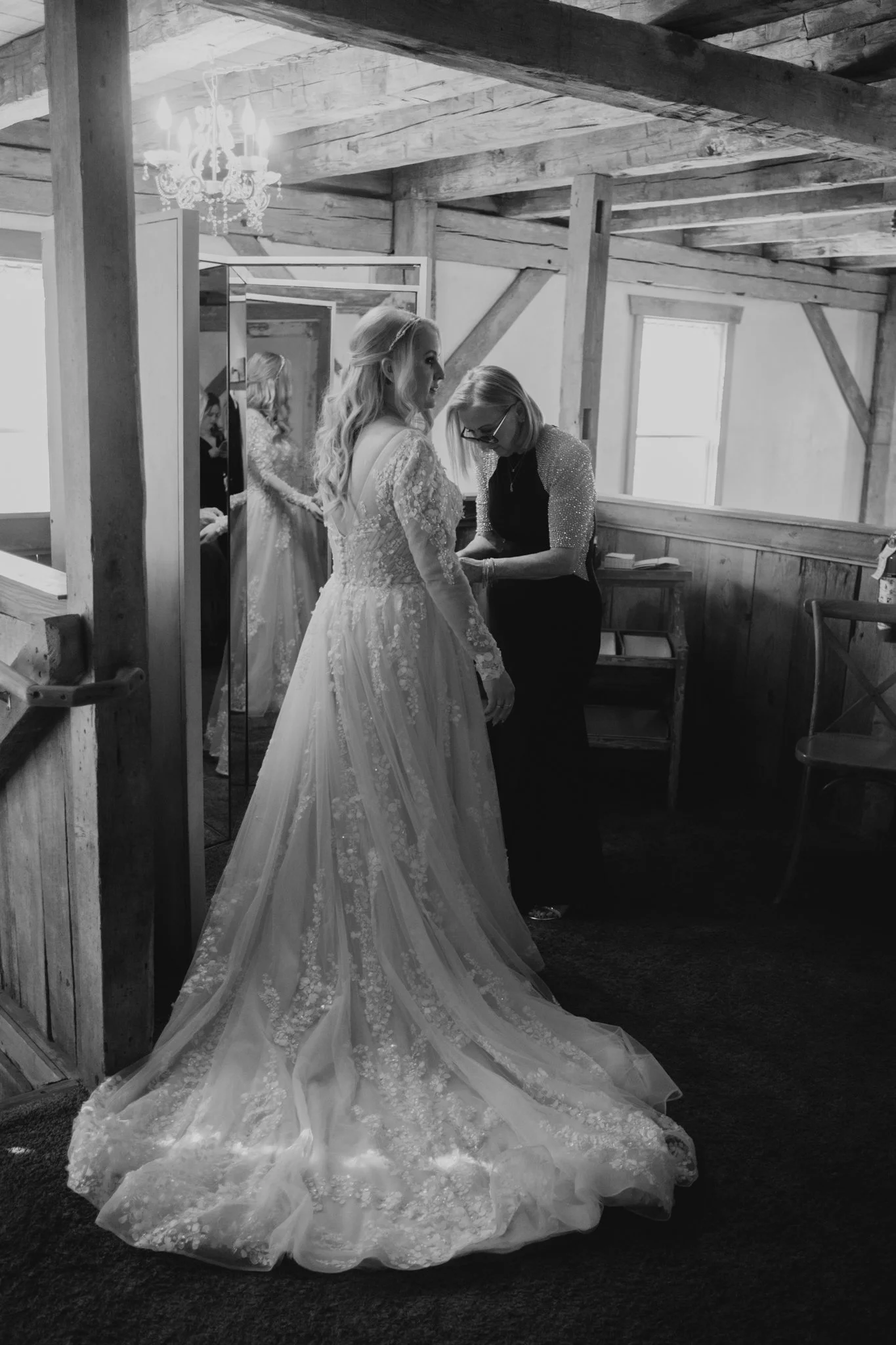 Bride getting into her lace gown before her dark and moody fall wedding at Shenandoah Mill