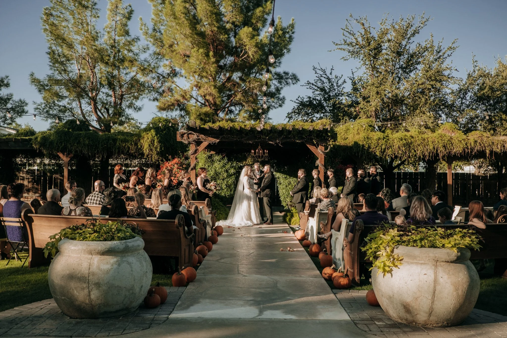 Outdoor Fall ceremony details with pumpkins tucked along the aisle