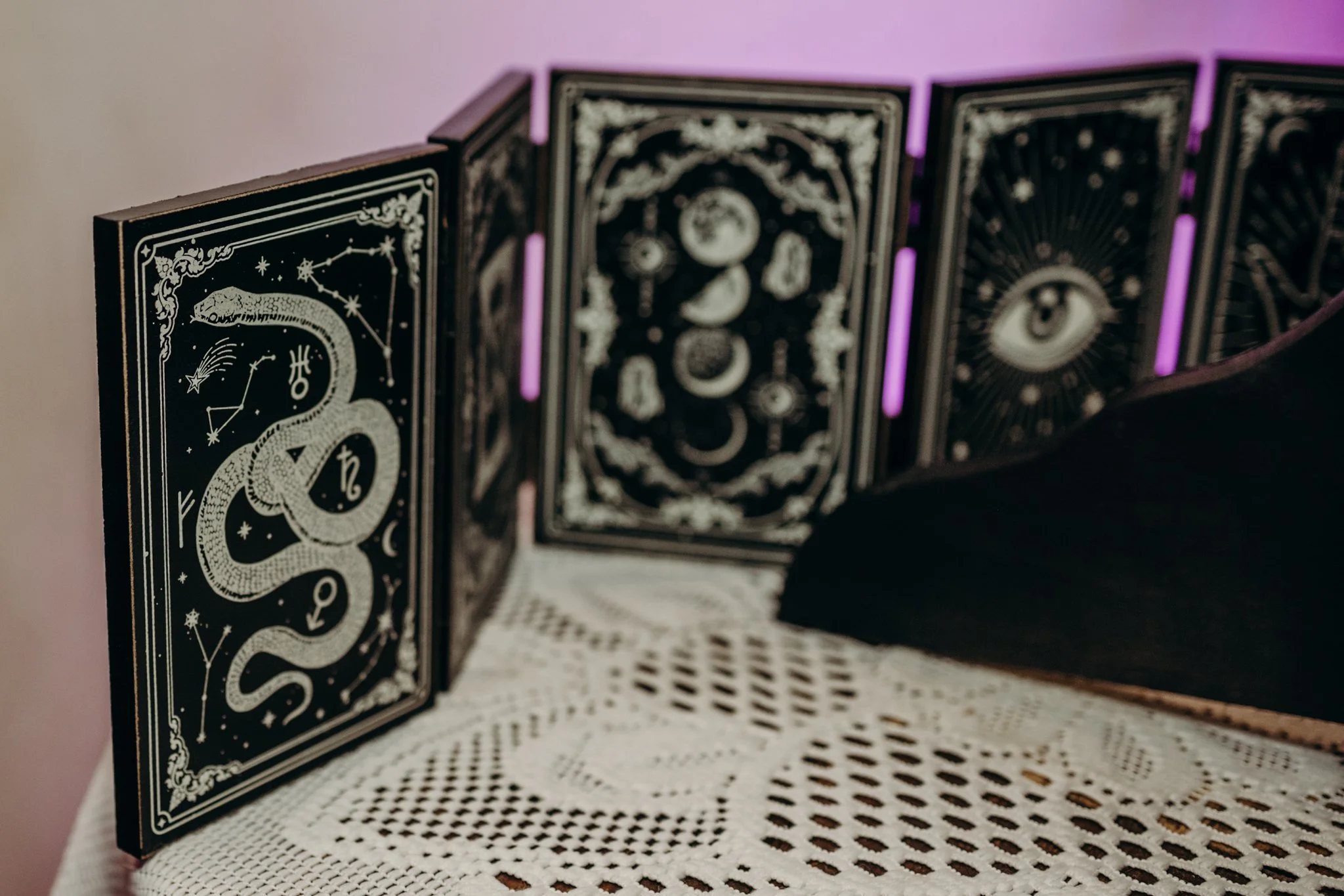 Celestial snake and moon screen as spooky decor at a dark and moody wedding