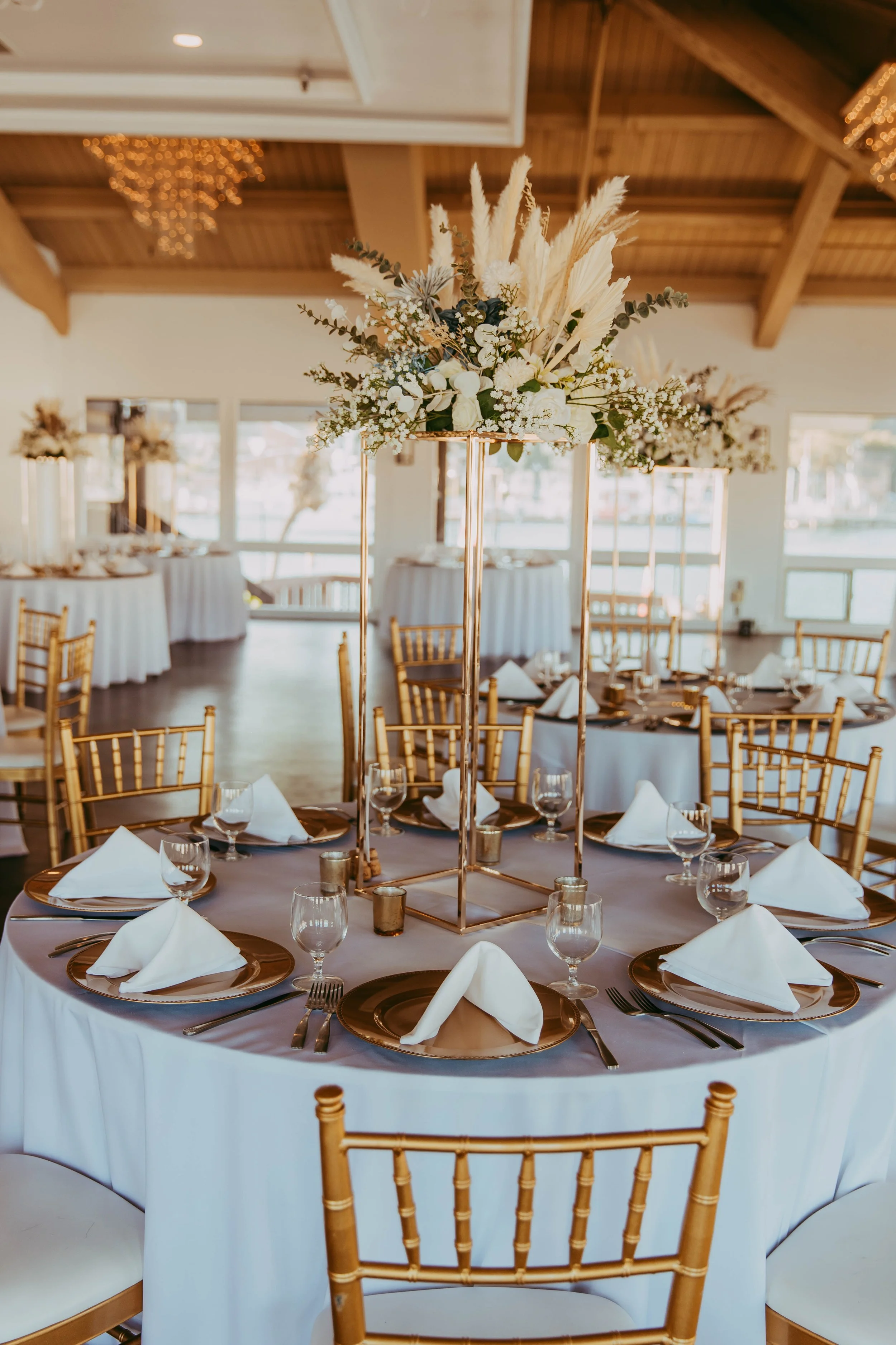 Reception table with a pampas centerpiece and gold chargers at a Dana Point Yacht Club wedding