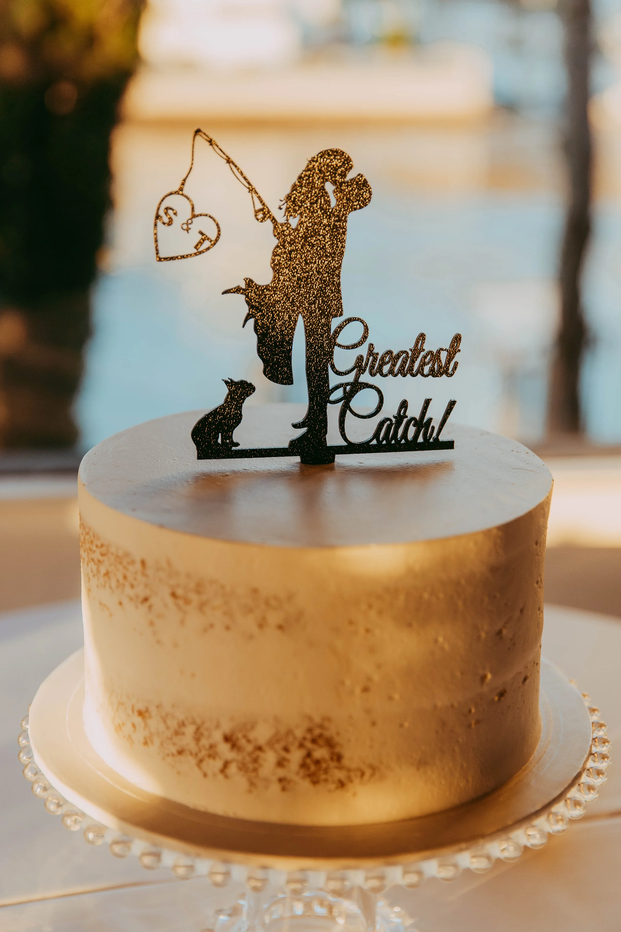 Buttercream wedding cake with a Greatest Catch fishing topper at a Dana Point reception