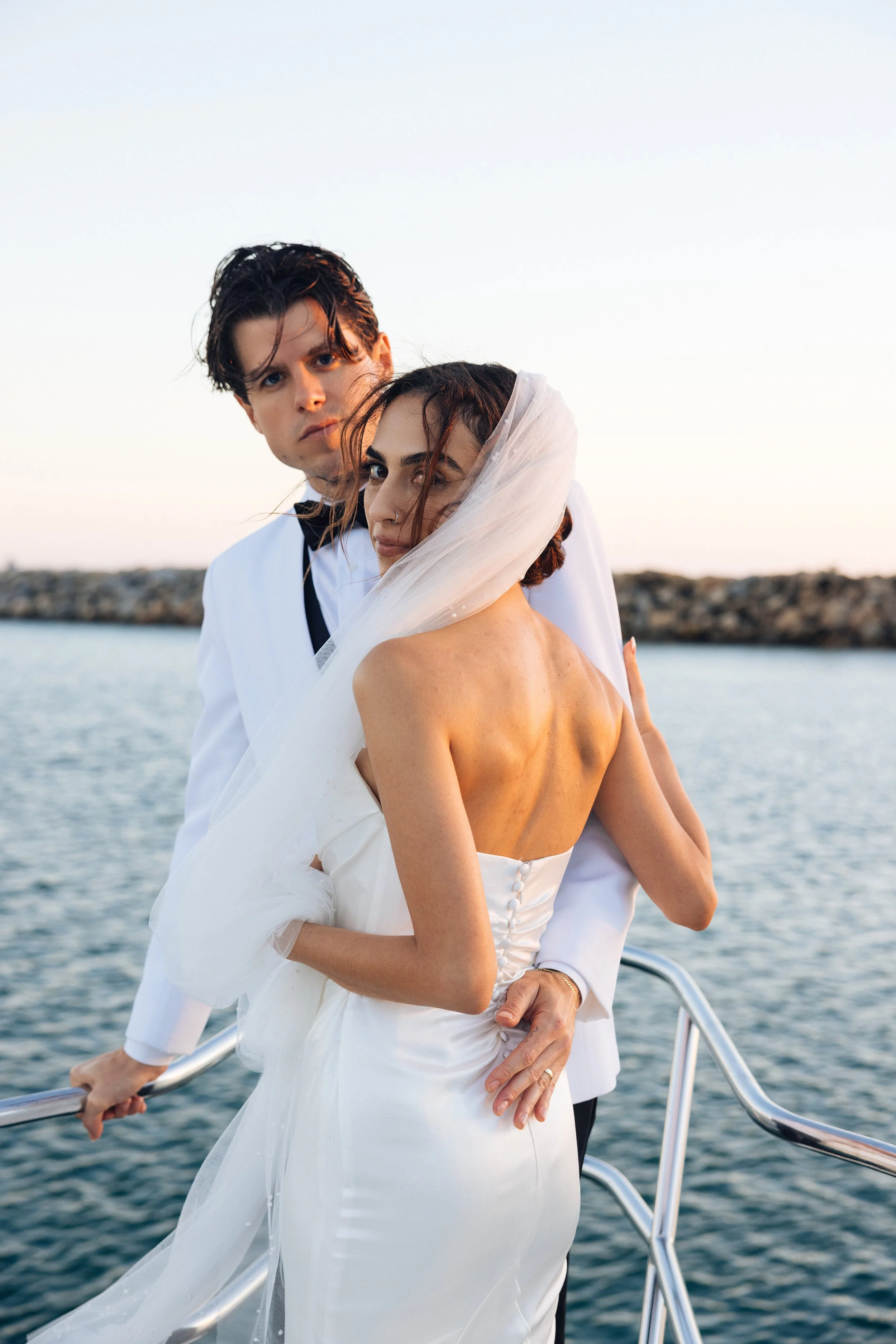 Newlyweds on a yacht at sunset near the Dana Point Harbor breakwater