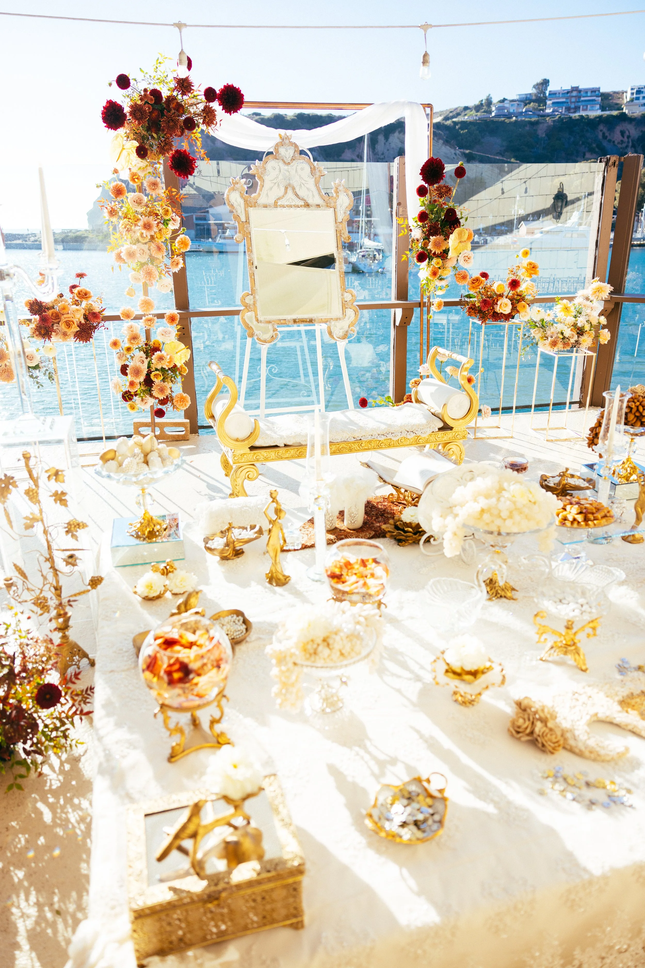 Gold Persian sofreh aghd spread set against Dana Point Harbor at a Yacht Club wedding