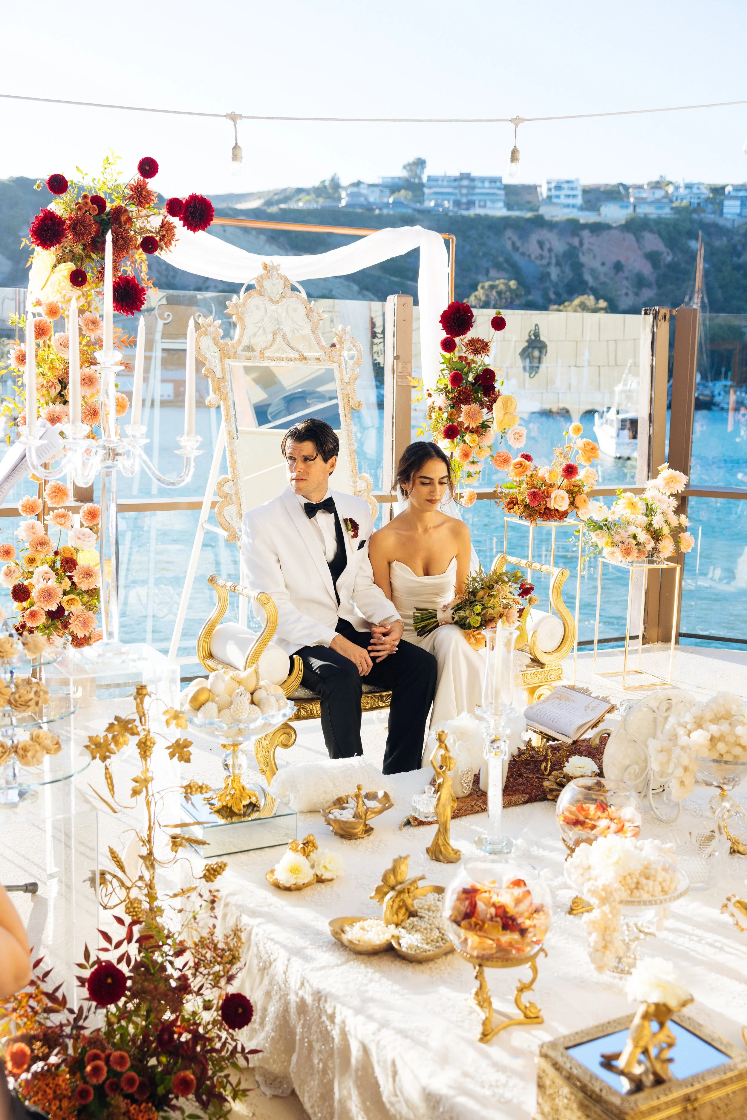 Couple seated at their sofreh during a Persian ceremony at Dana Point Yacht Club