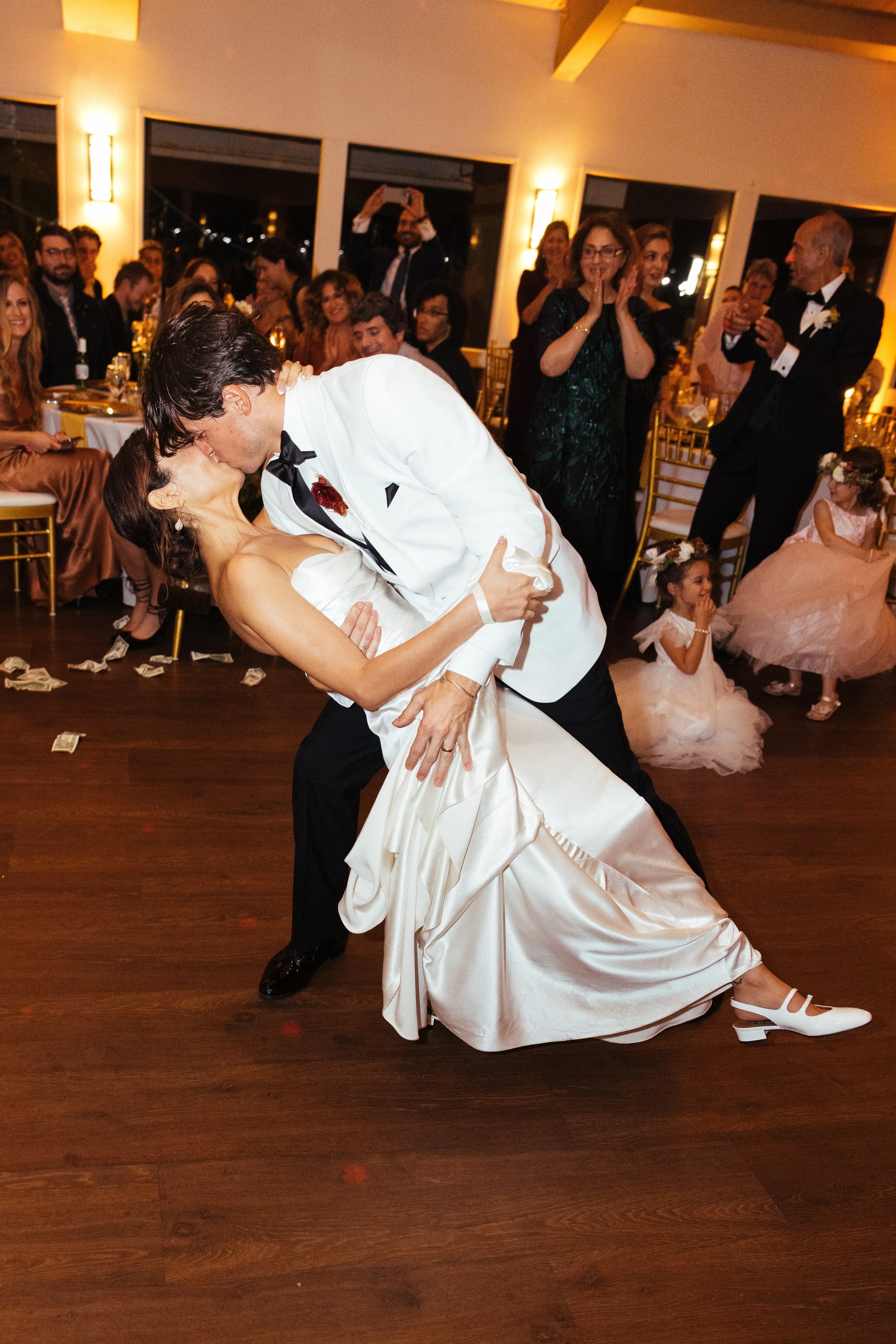 Groom dips the bride for a first-dance kiss at a Dana Point Yacht Club reception