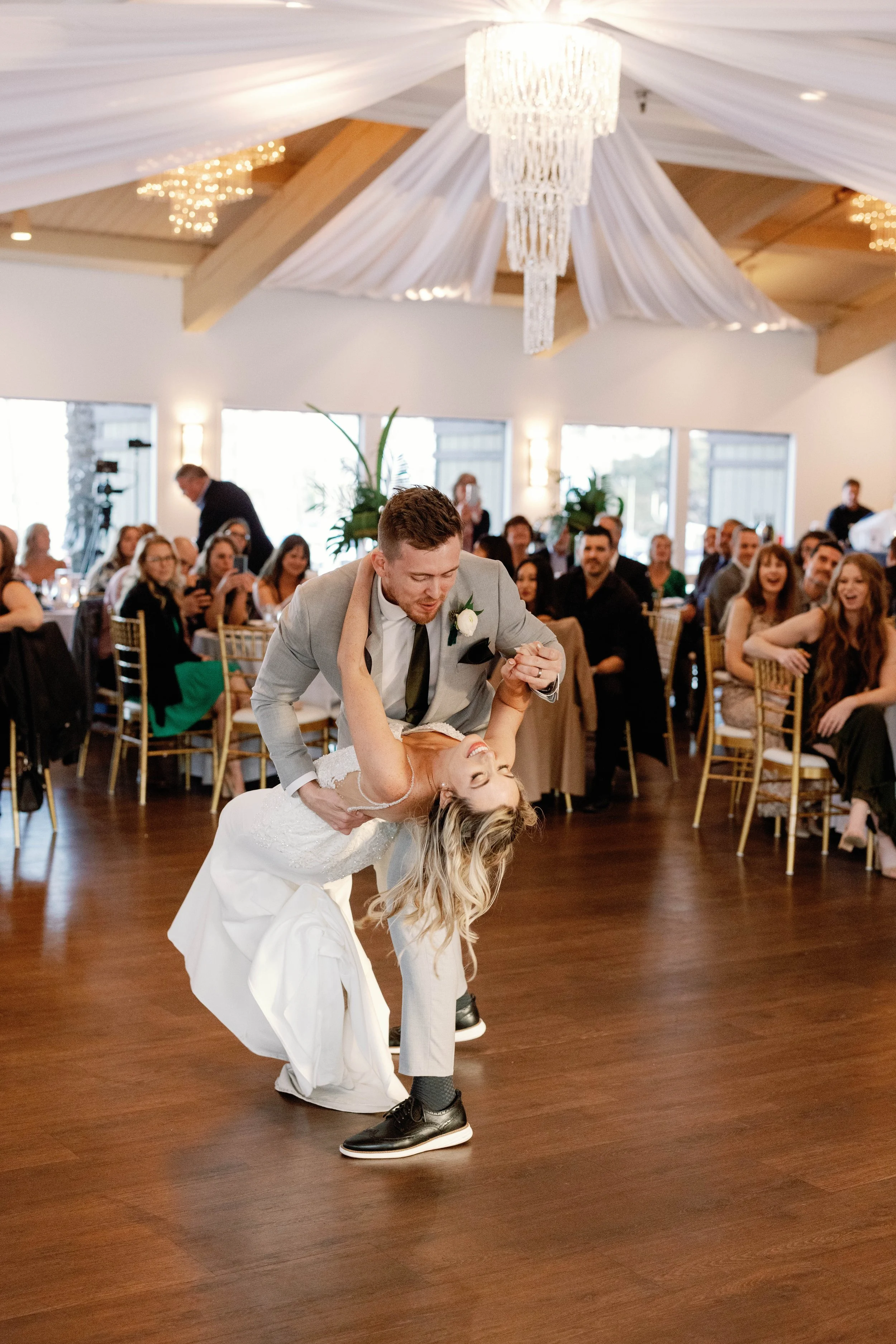 Groom dips the bride during their first dance at a Dana Point Yacht Club reception