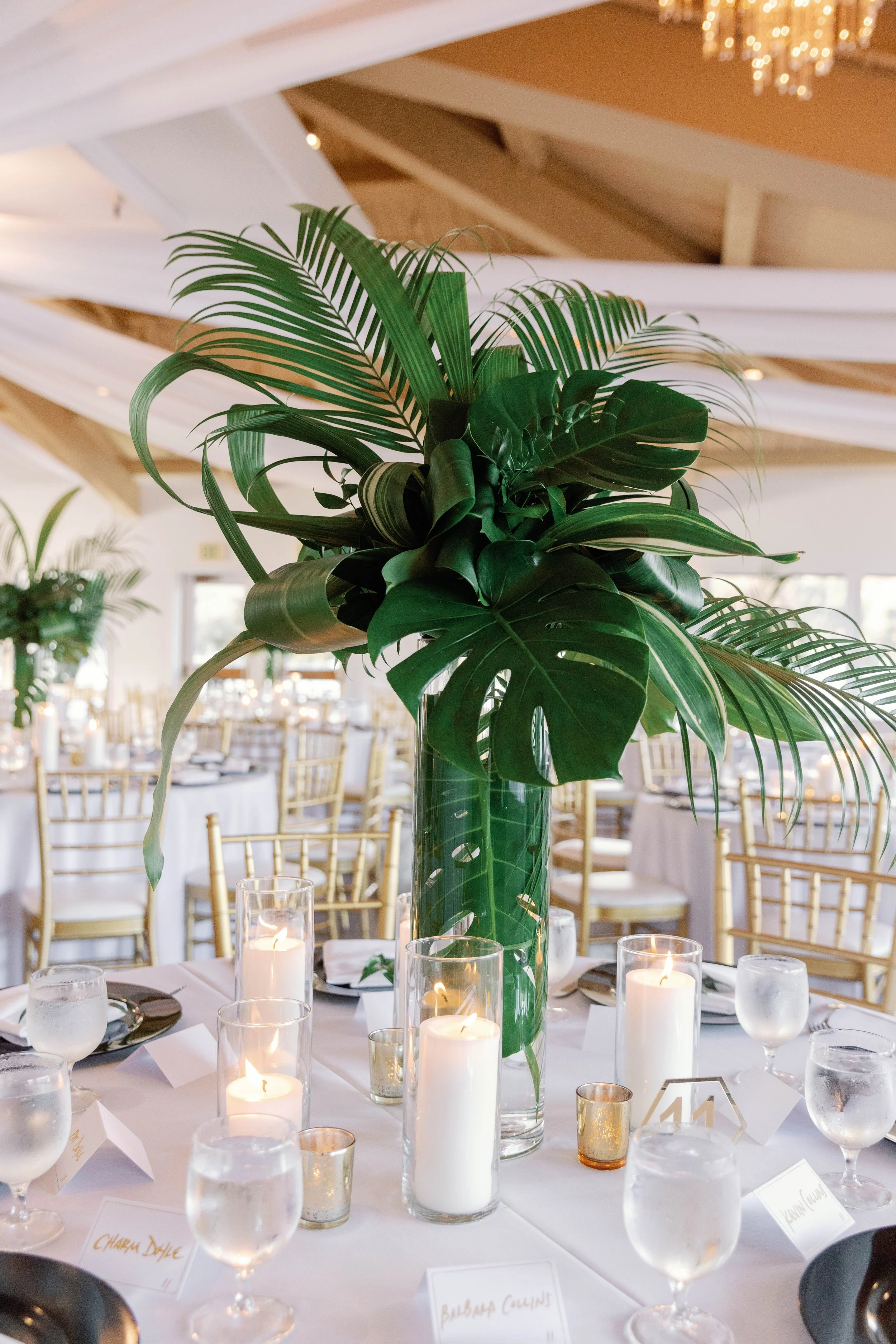 Tall tropical palm centerpiece with candles at a Dana Point Yacht Club reception