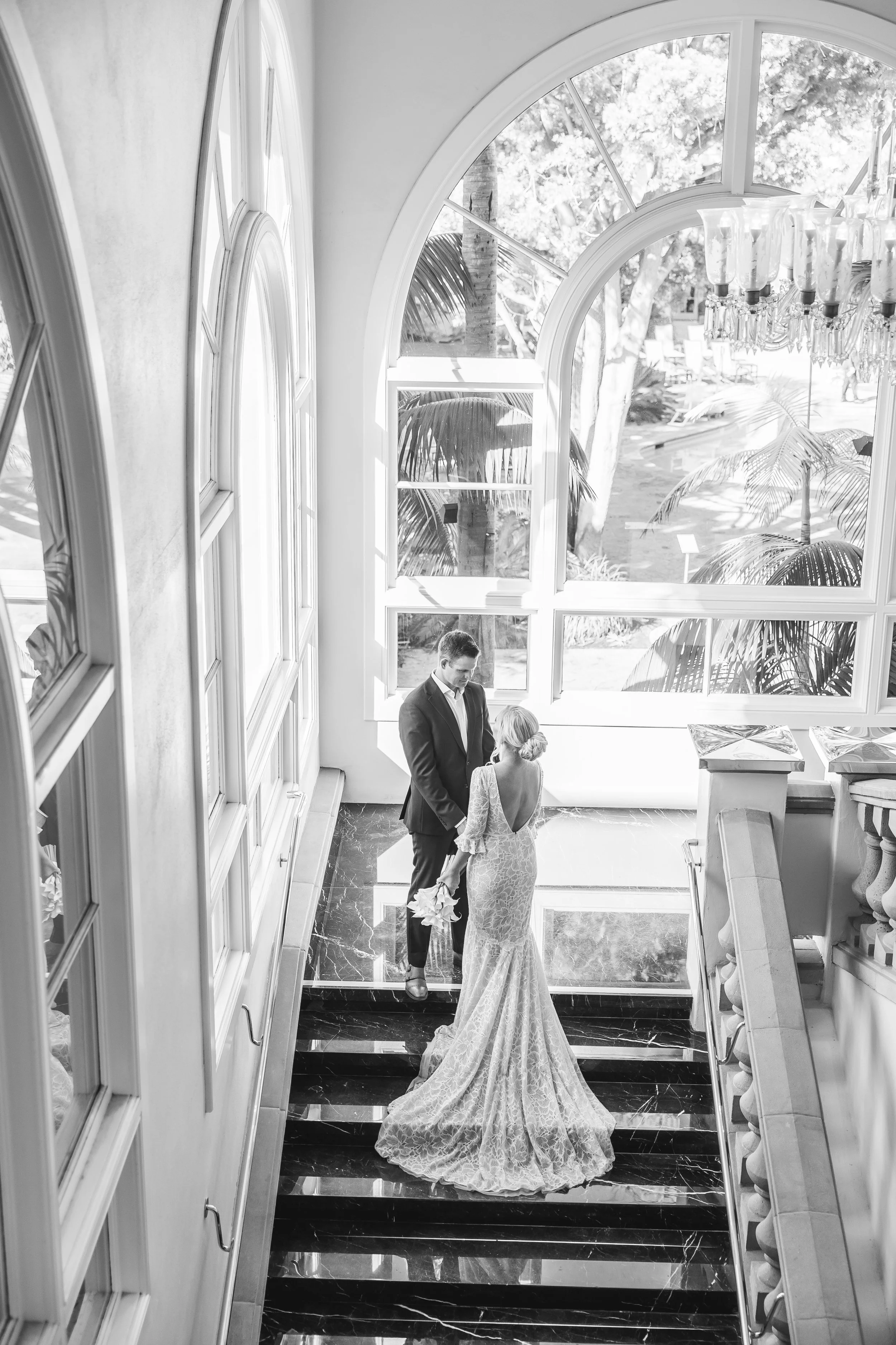 Bride and groom on a grand marble staircase at an oceanfront resort near Dana Point