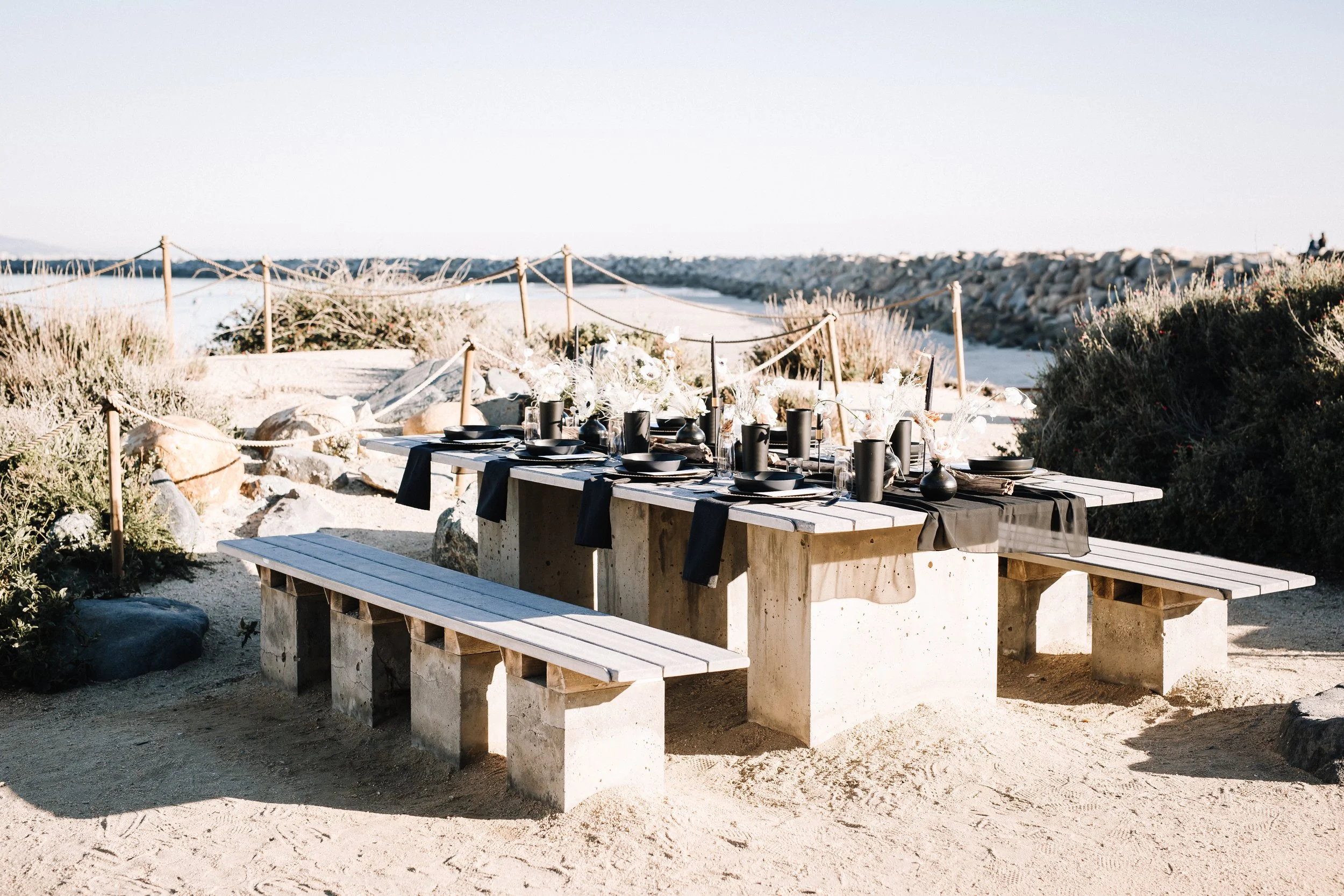 Moody black reception table with anemones and candles overlooking the harbor at Dana Point