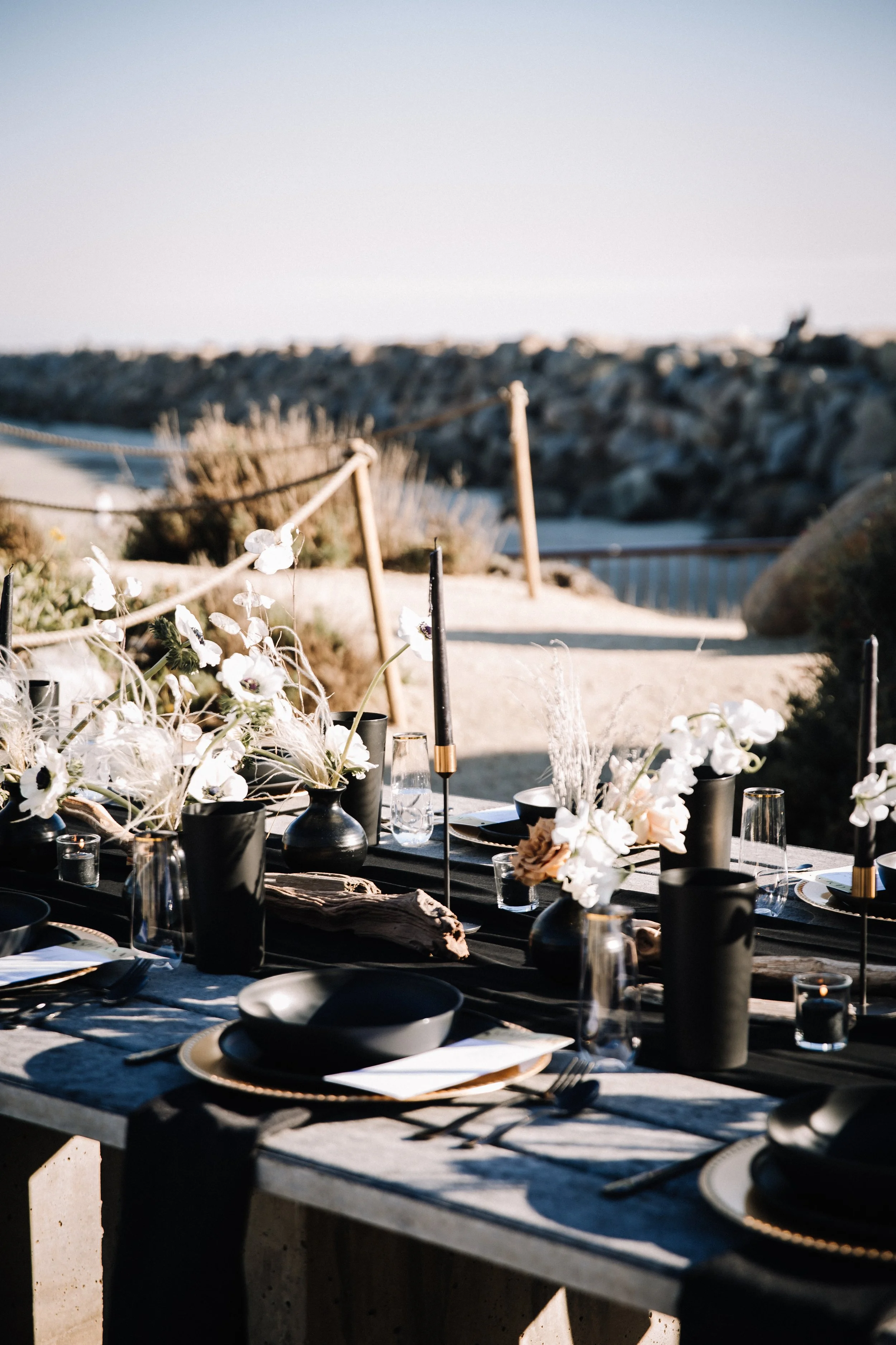 Moody black reception table with anemones and candles overlooking the harbor at Dana Point