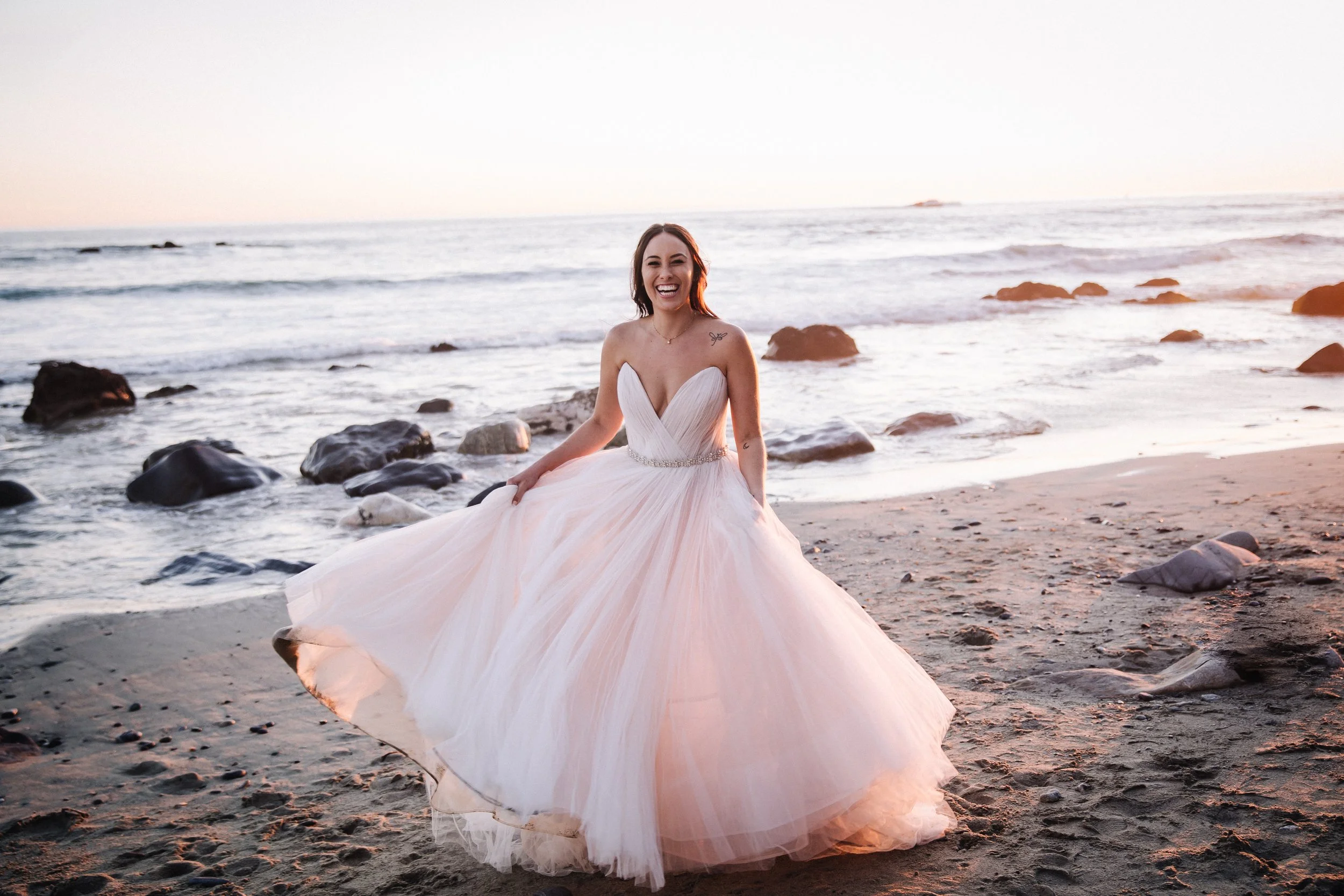 First look by the venue as a bride in a blush gown approaches the groom at a Dana Point wedding