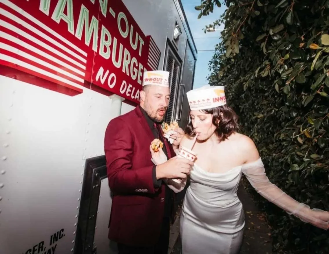 non-traditional wedding couple eating in front of the in-n-out truck