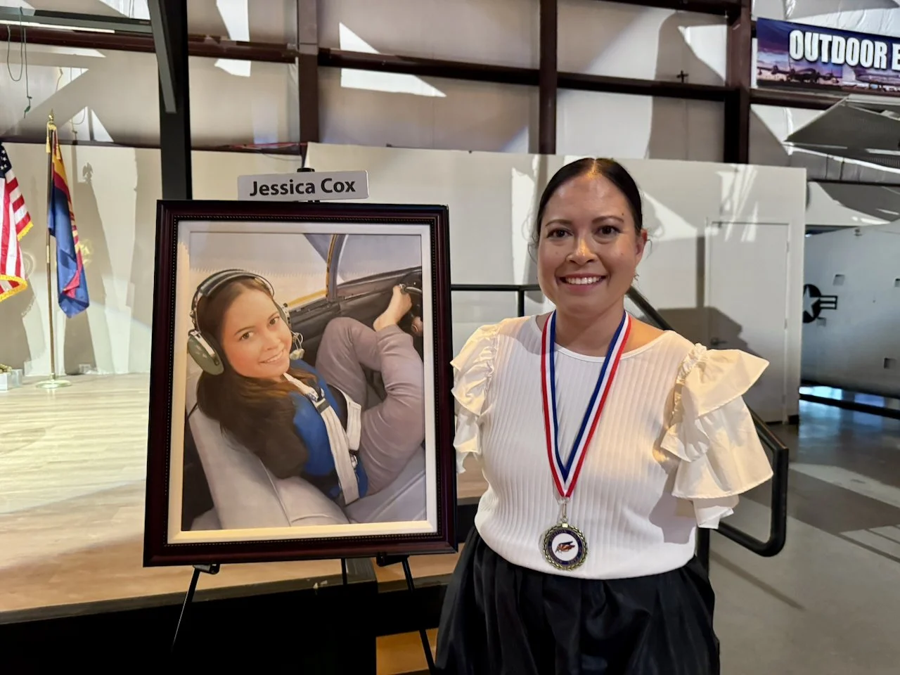 Jessica Cox stands next to her portrait that will hang in the Arizona Aviation Hall of Fame