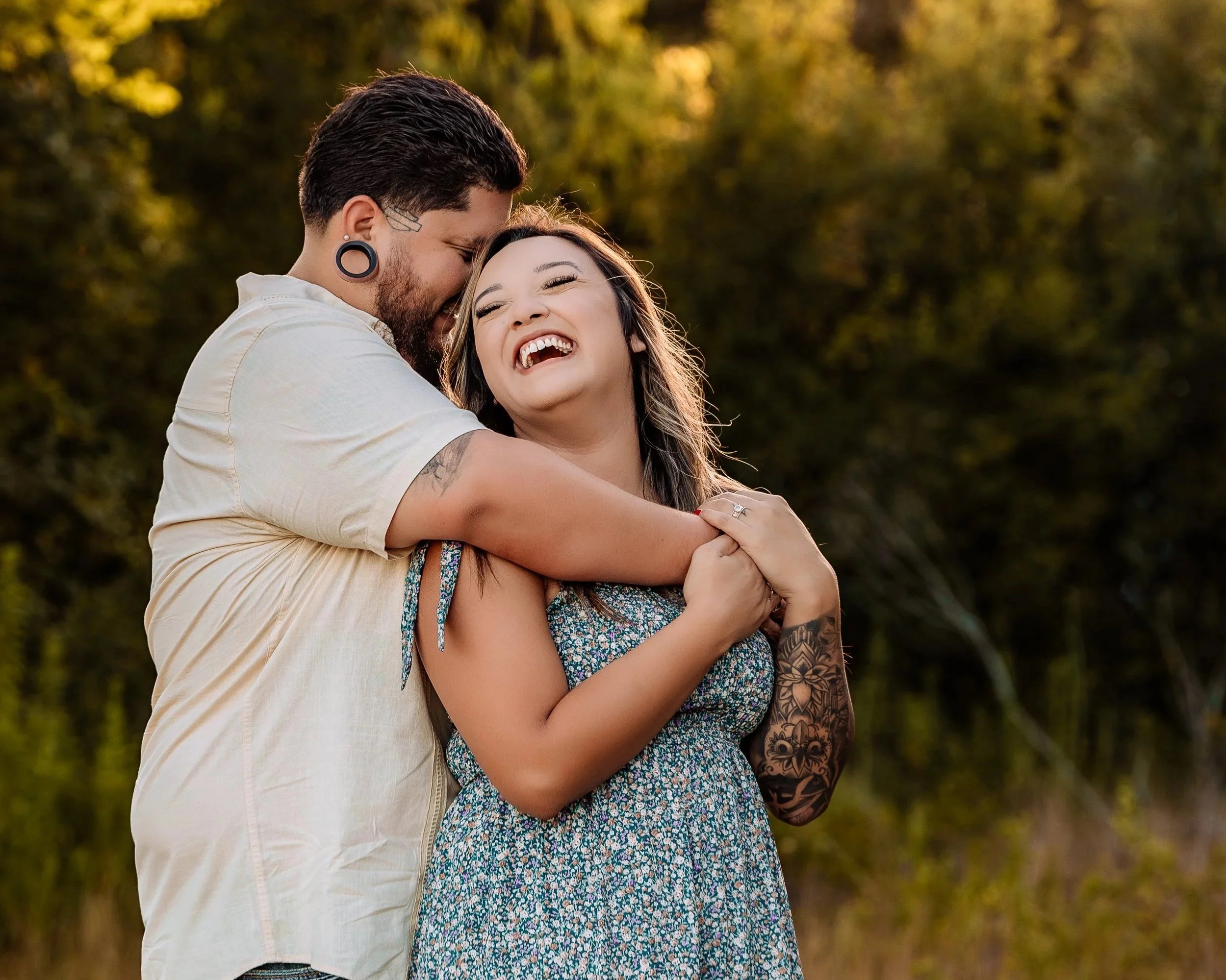 A happy couple embracing outdoors during sunset, laughing and smiling
