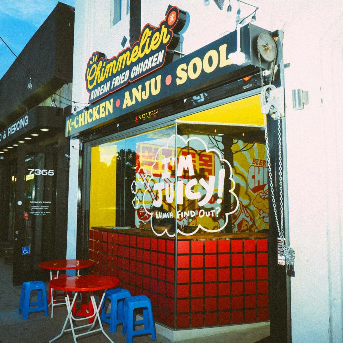 Chimmelier Korean Fried Chicken storefront in Los Angeles, with a navy K-Chicken, Anju, and Sool sign band, hand-lettered I'm Juicy window graphics, and a red tile facade.