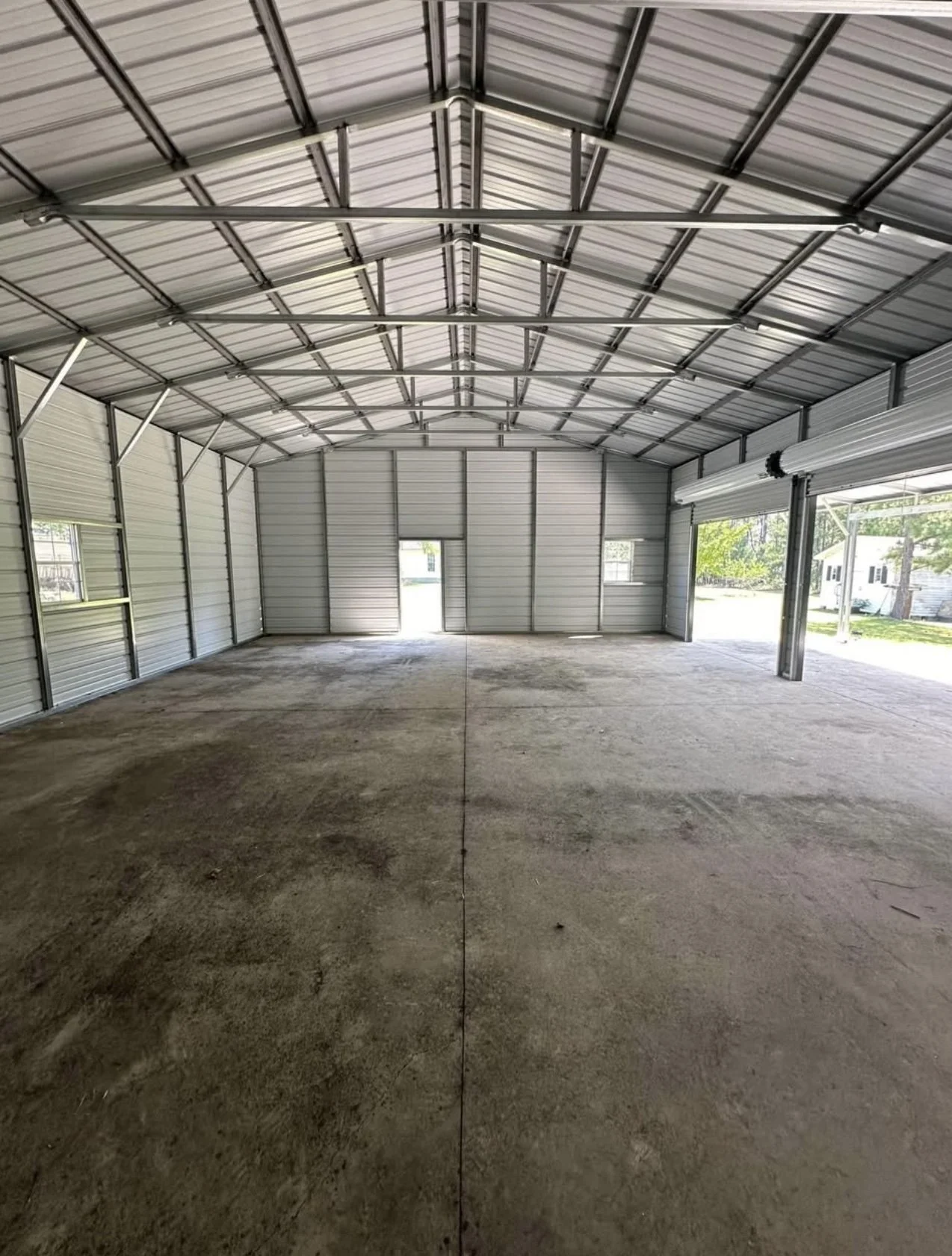 interior of a spacious metal garage with concrete floors