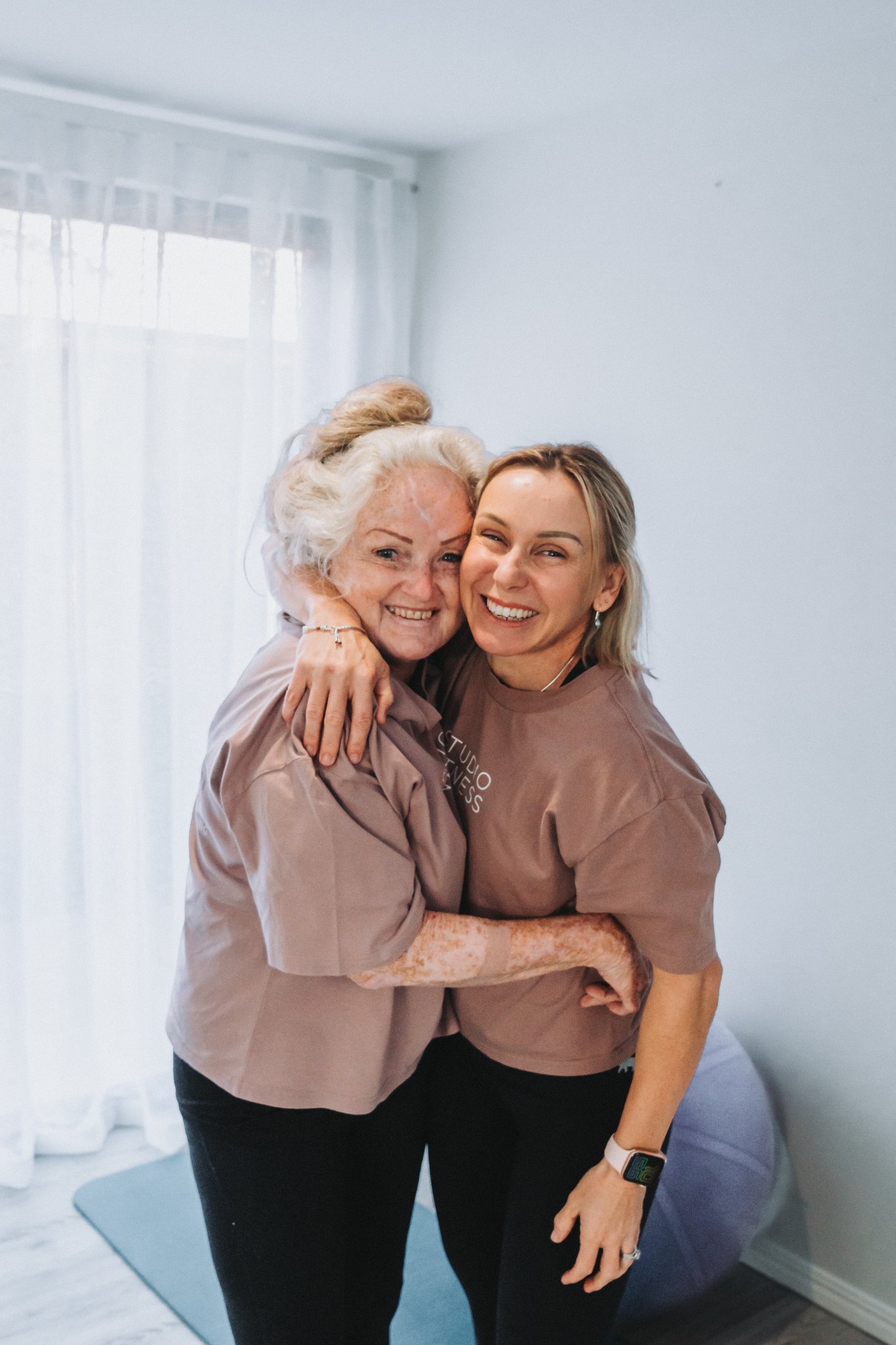 Mel and one of her female clients grinning ear to ear while in an embrace