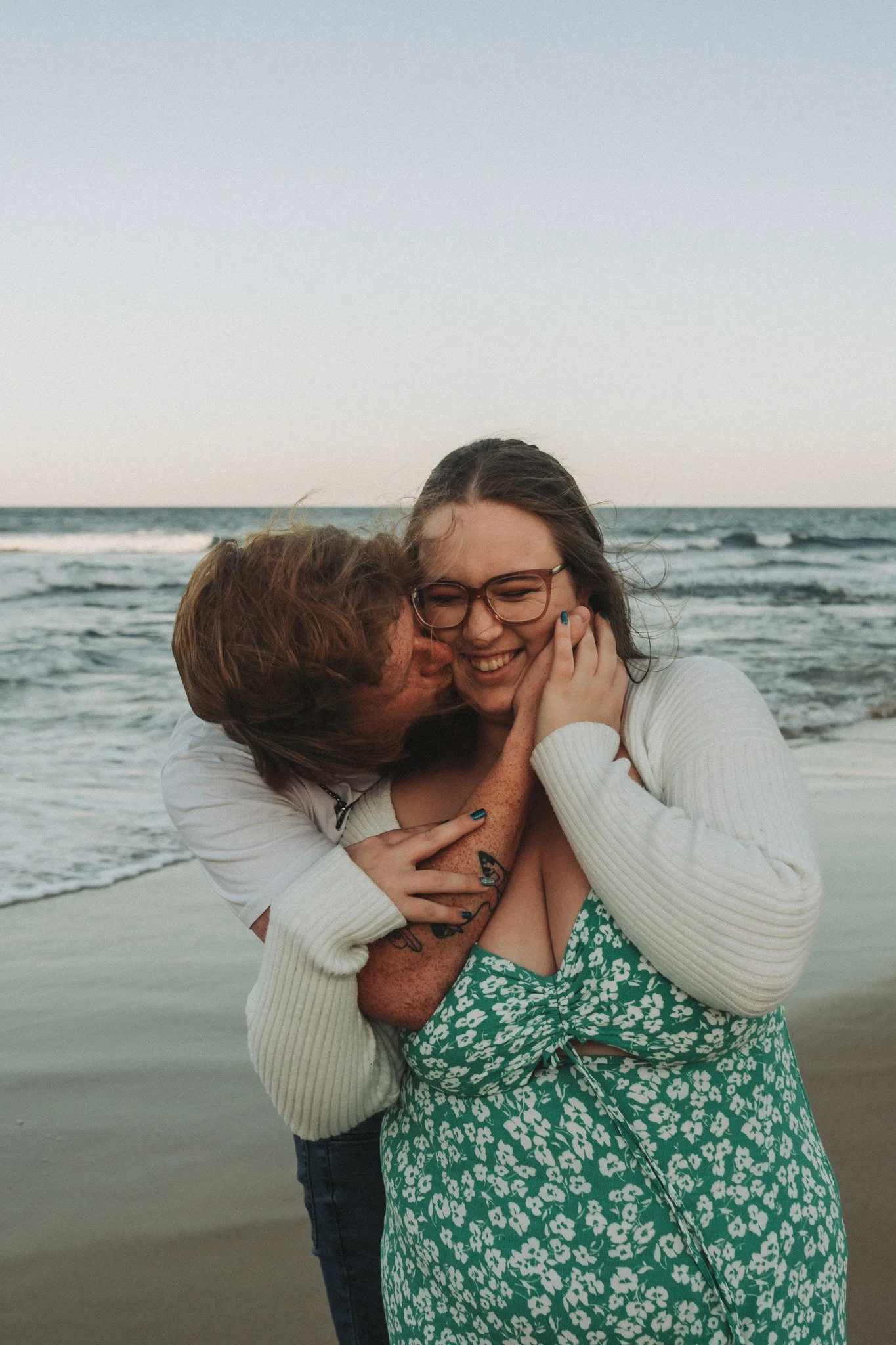 Sweet young couple snuggle and play at Dicky Beach, Sunshine Coast, QLD