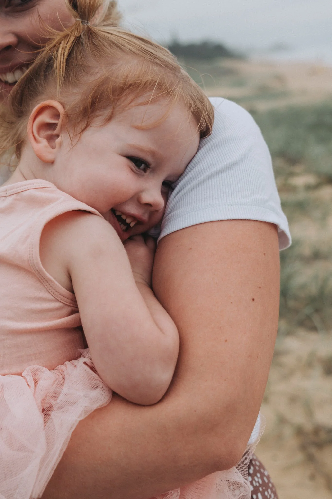 Little girl snuggling into Mummy laughing