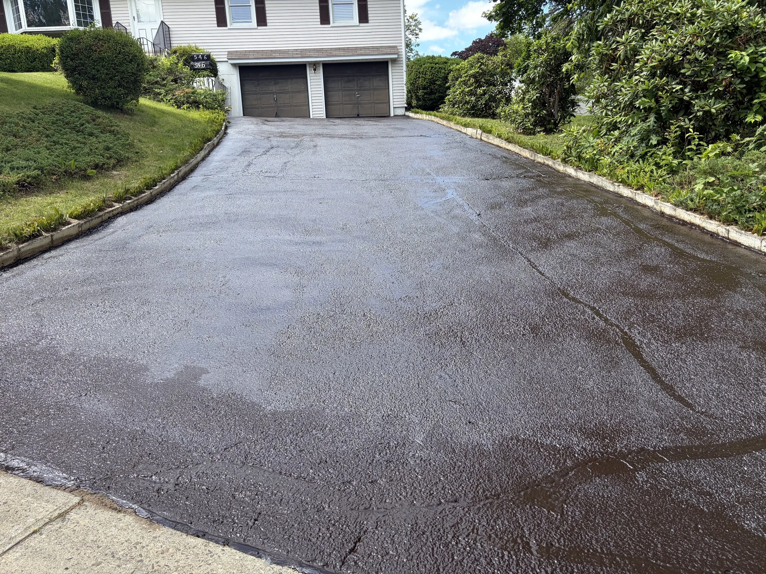 Freshly sealcoated asphalt driveway completed in Stratford.