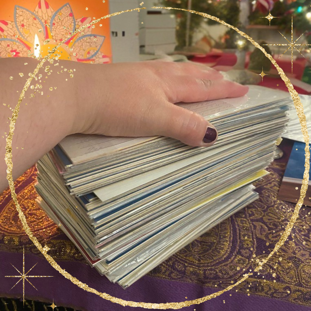Stack of SoulCollage® card deck with the hand of a white femme person resting on top.