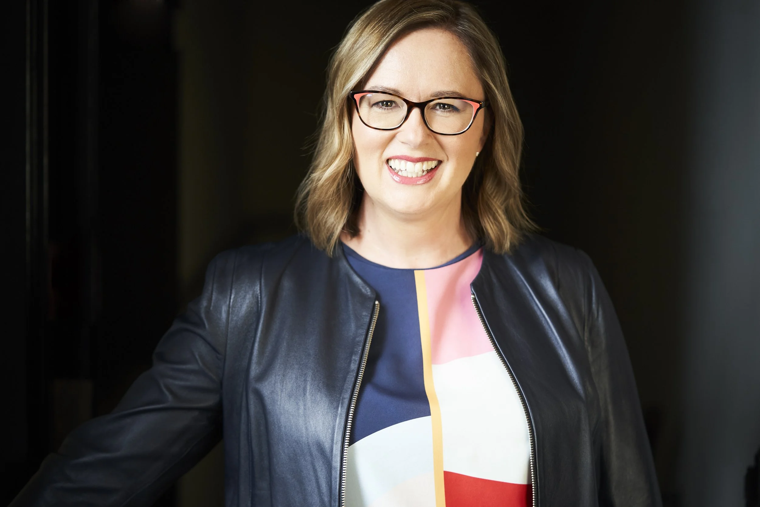 Tammy wearing a black leather jacket and smiling warmly