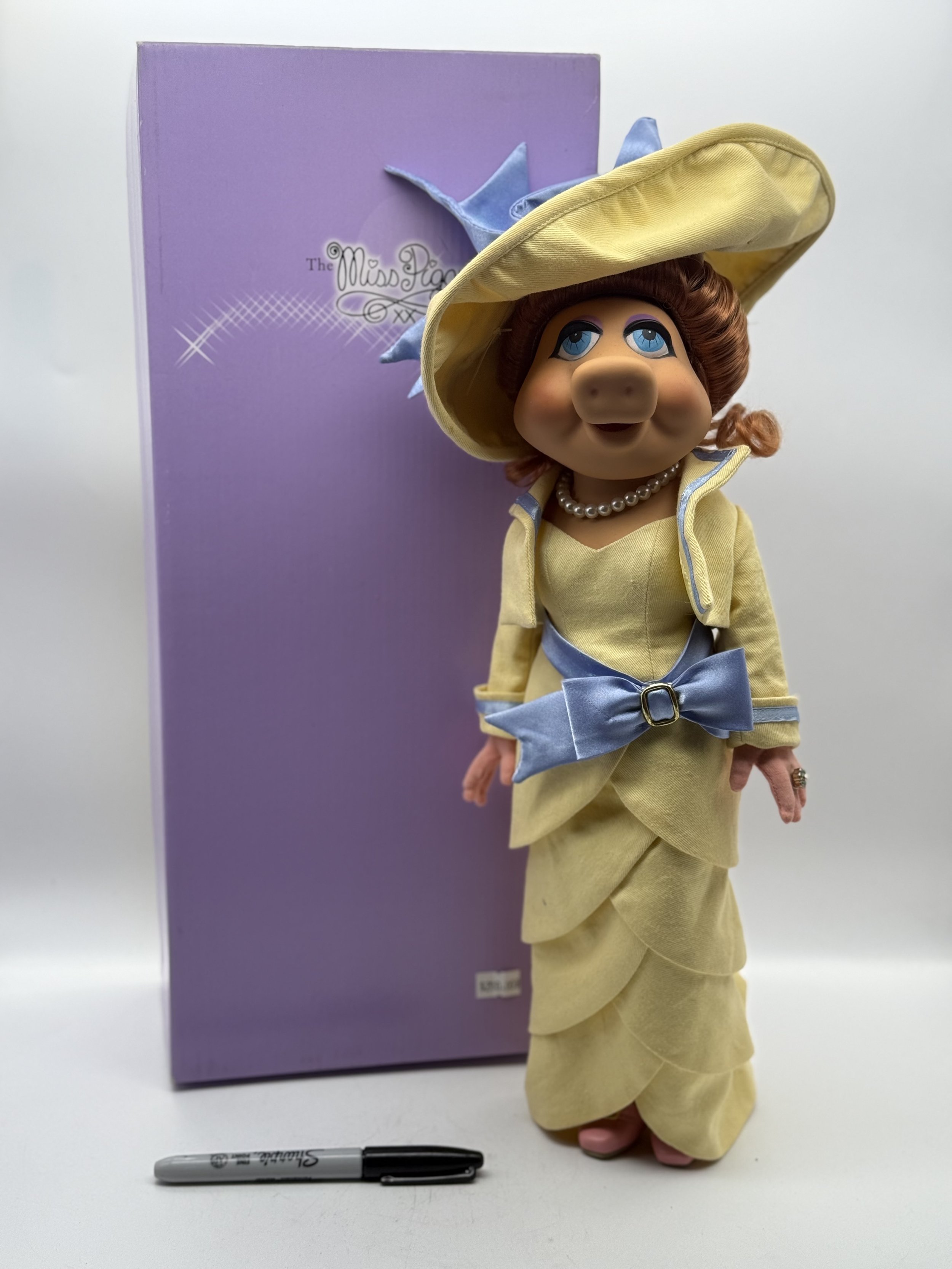 Tonner My Fair Piggy doll standing beside her box, marker for scale