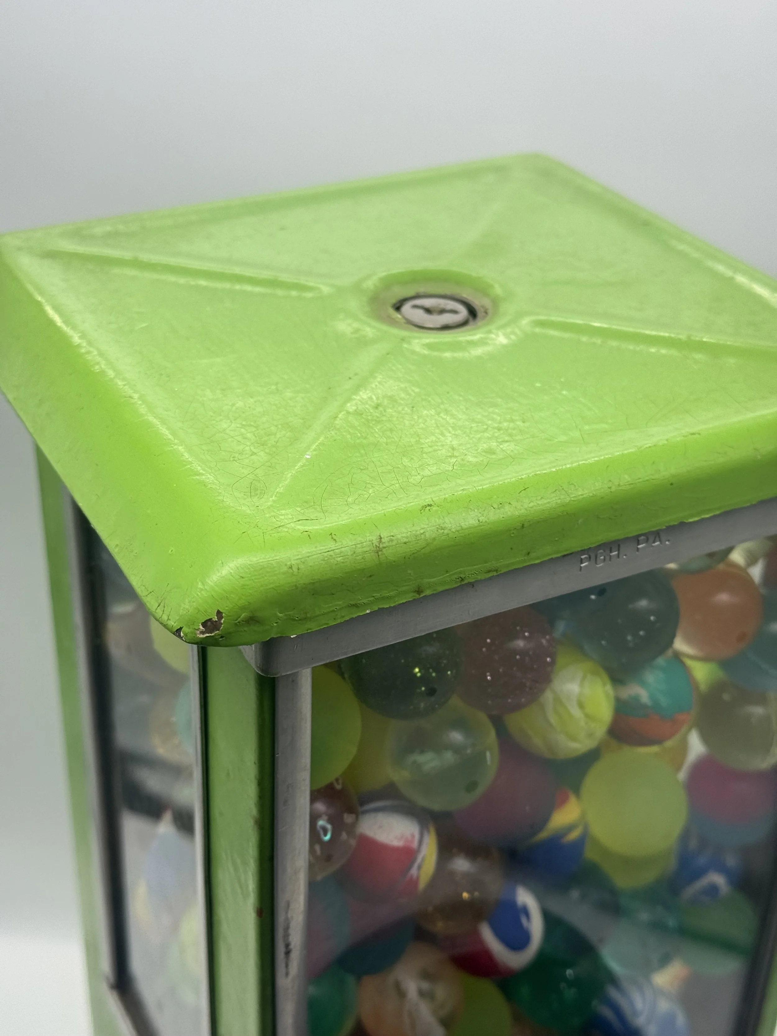 Top of the gumball machine showing the green lid and lock