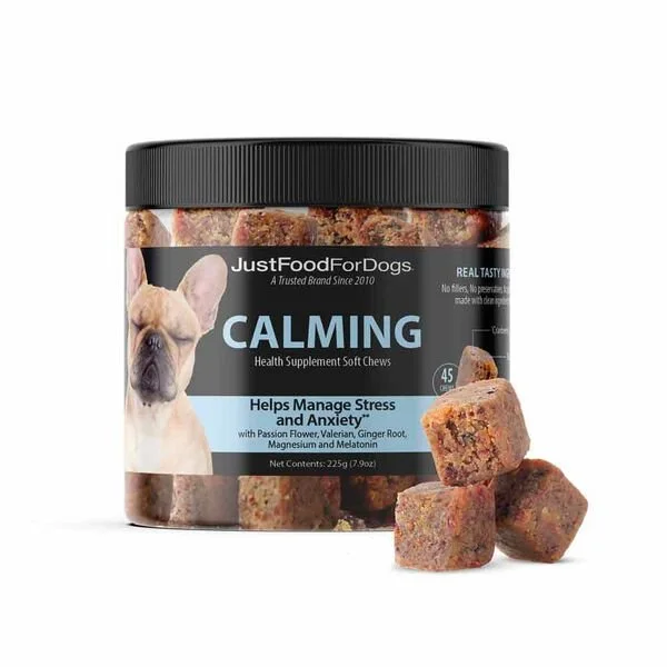 Container of calming soft chews for dogs labeled 'JustFoodForDogs,' with three chews outside the container showing a textured surface.