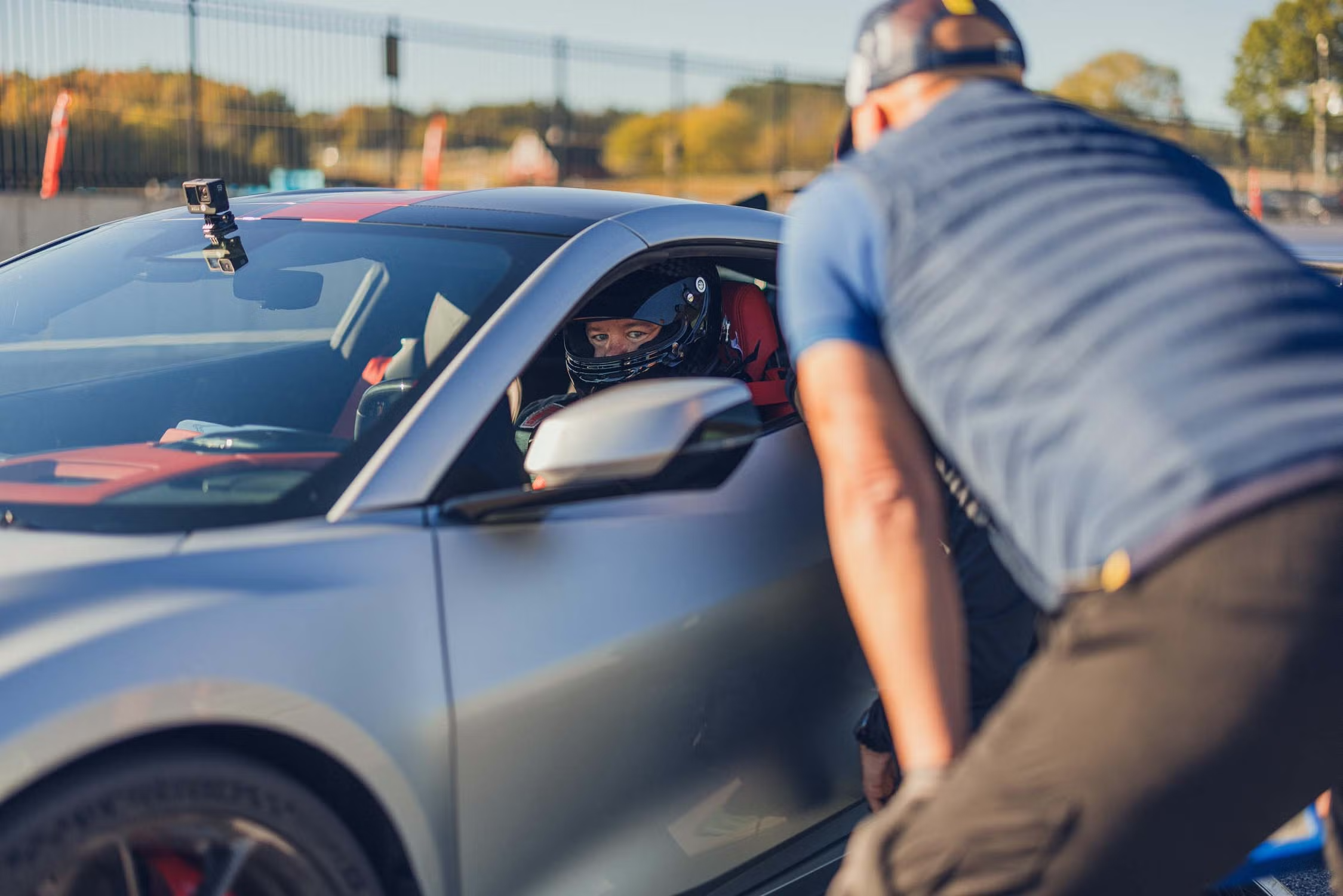 Driver team member checking-in with driver in vehicle before heading out on track