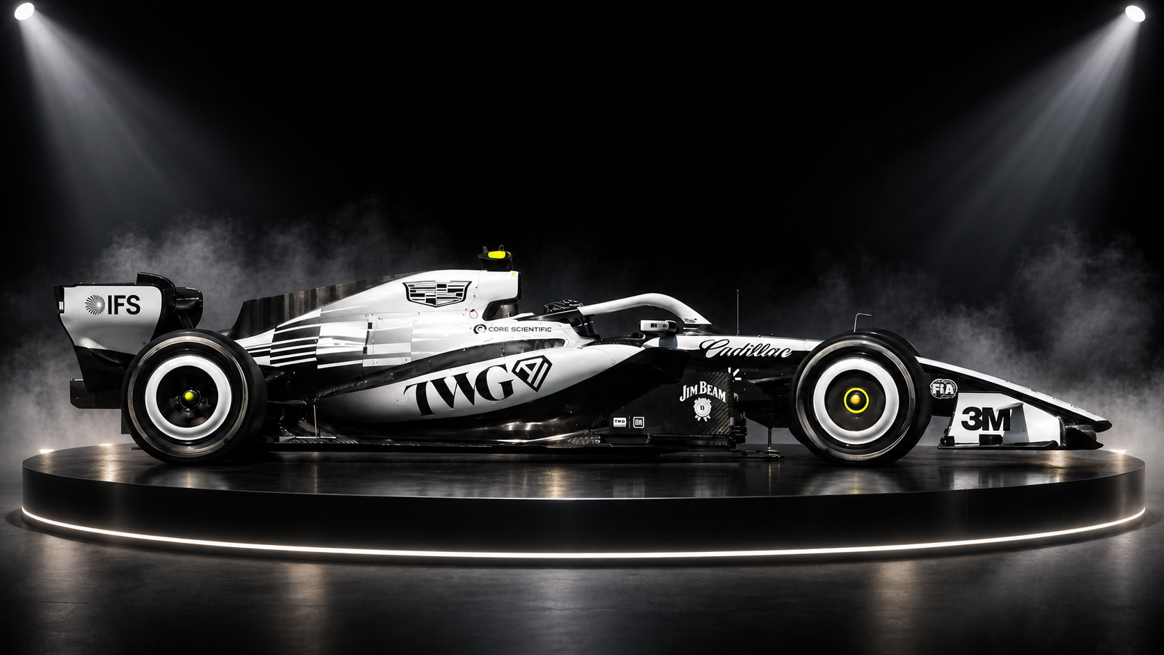 Black-and-white open-wheel race car displayed under dramatic spotlights on a dark platform.