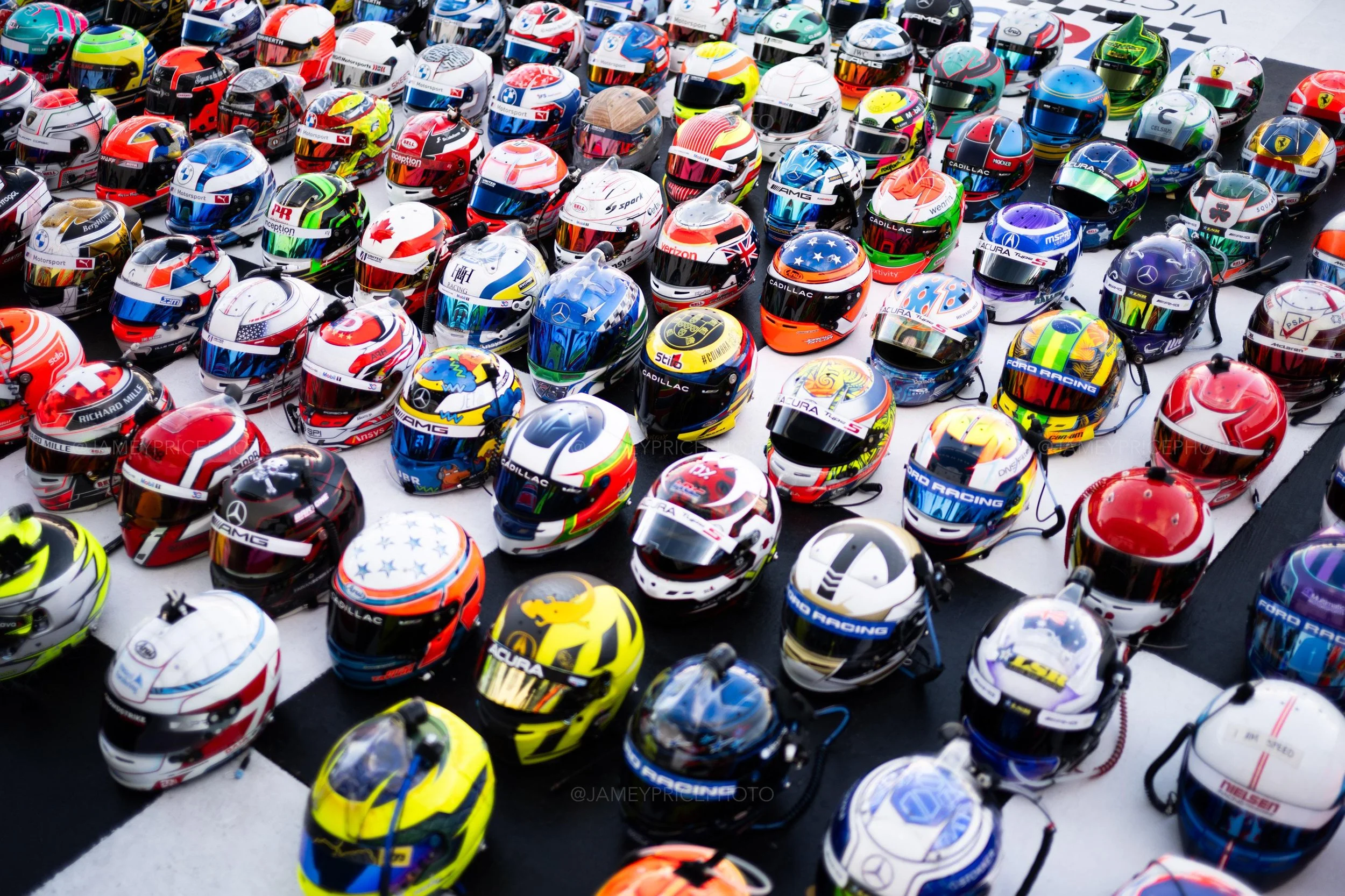 Racing helmets lined up in a grid at the track finish line