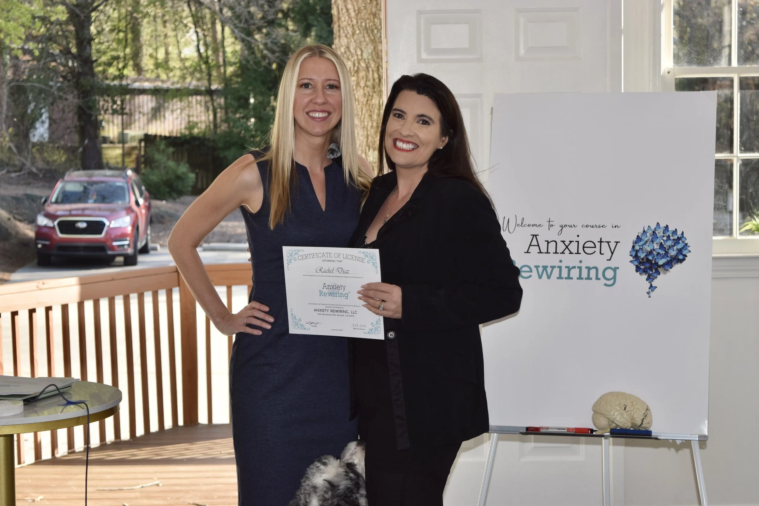 A therapist in a light green shirt assisting a person lying on a massage table with leg stretching exercises in a treatment room.