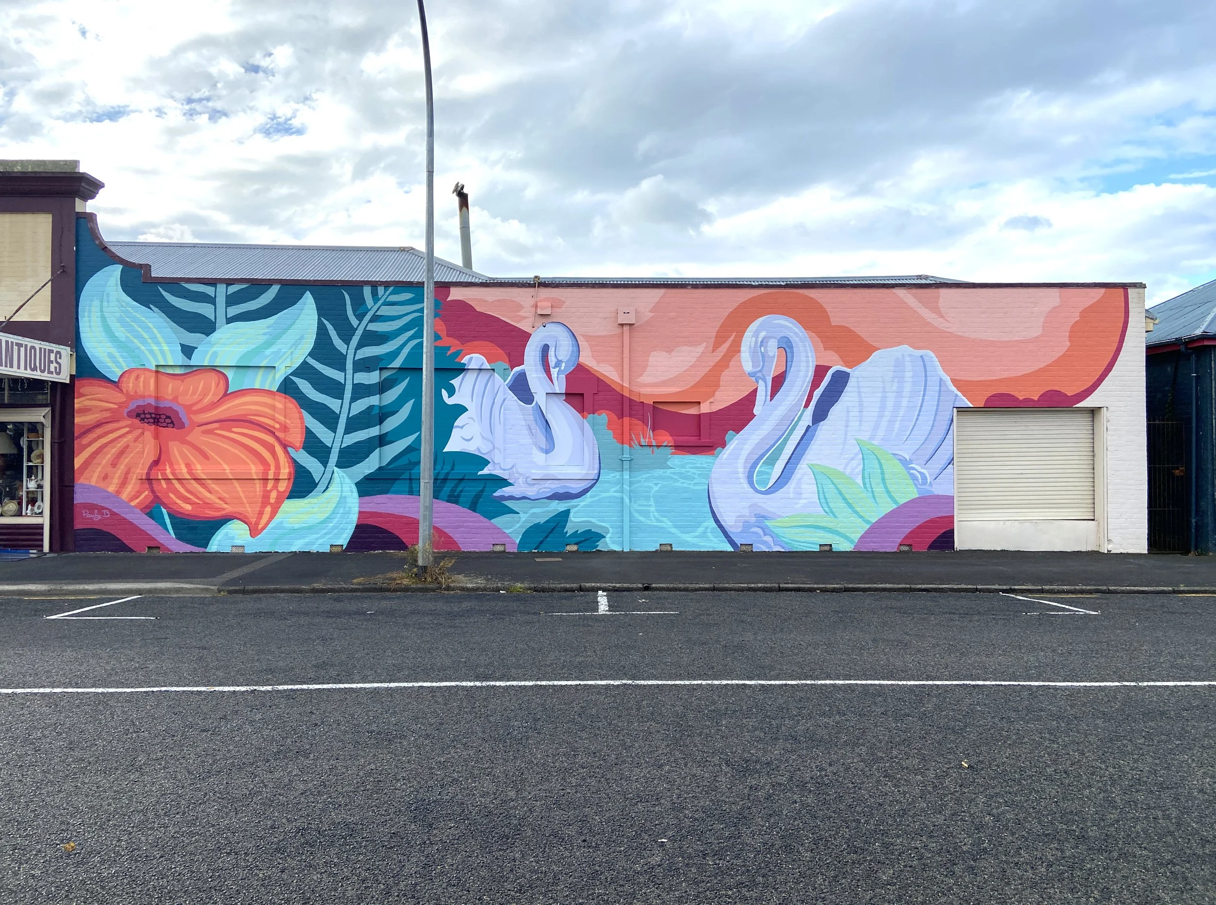  Hauraki District Council / Paeroa 

 This mural grew from conversations with Paeroa locals about what their town means to them. Two themes emerged strongly: the historically significant Ohinemuri River and the town's beloved antique shops. A pair of