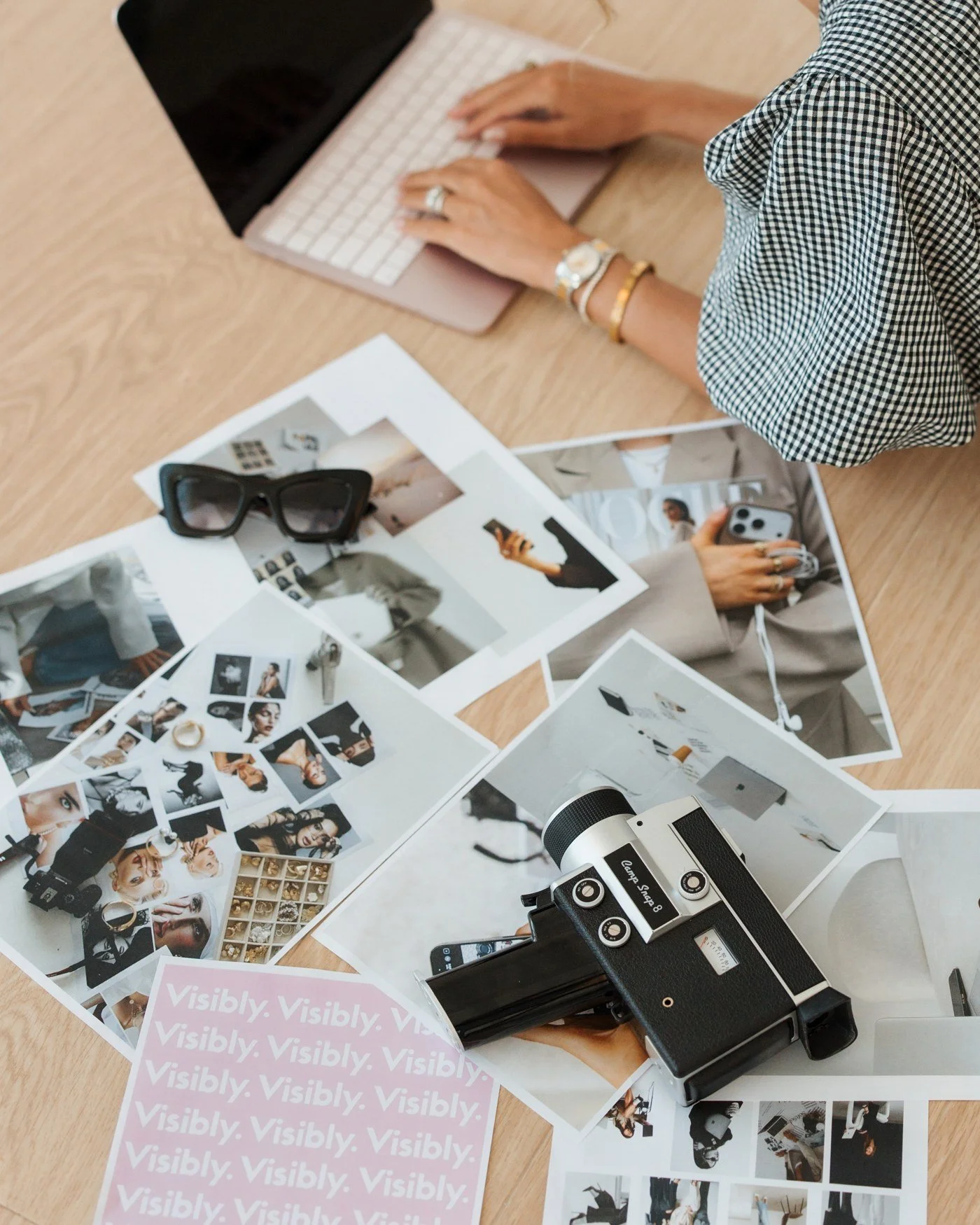 Campaign moodboards, a laptop and a film camera at Visibly HQ
