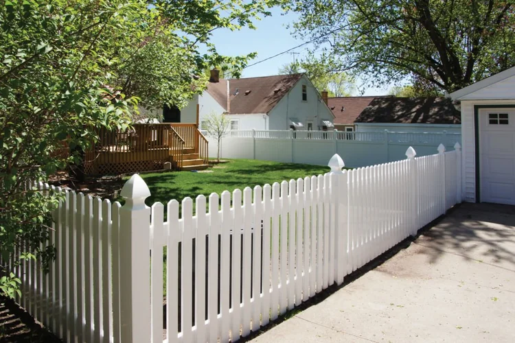 White vinyl picket fencing installed in a backyard