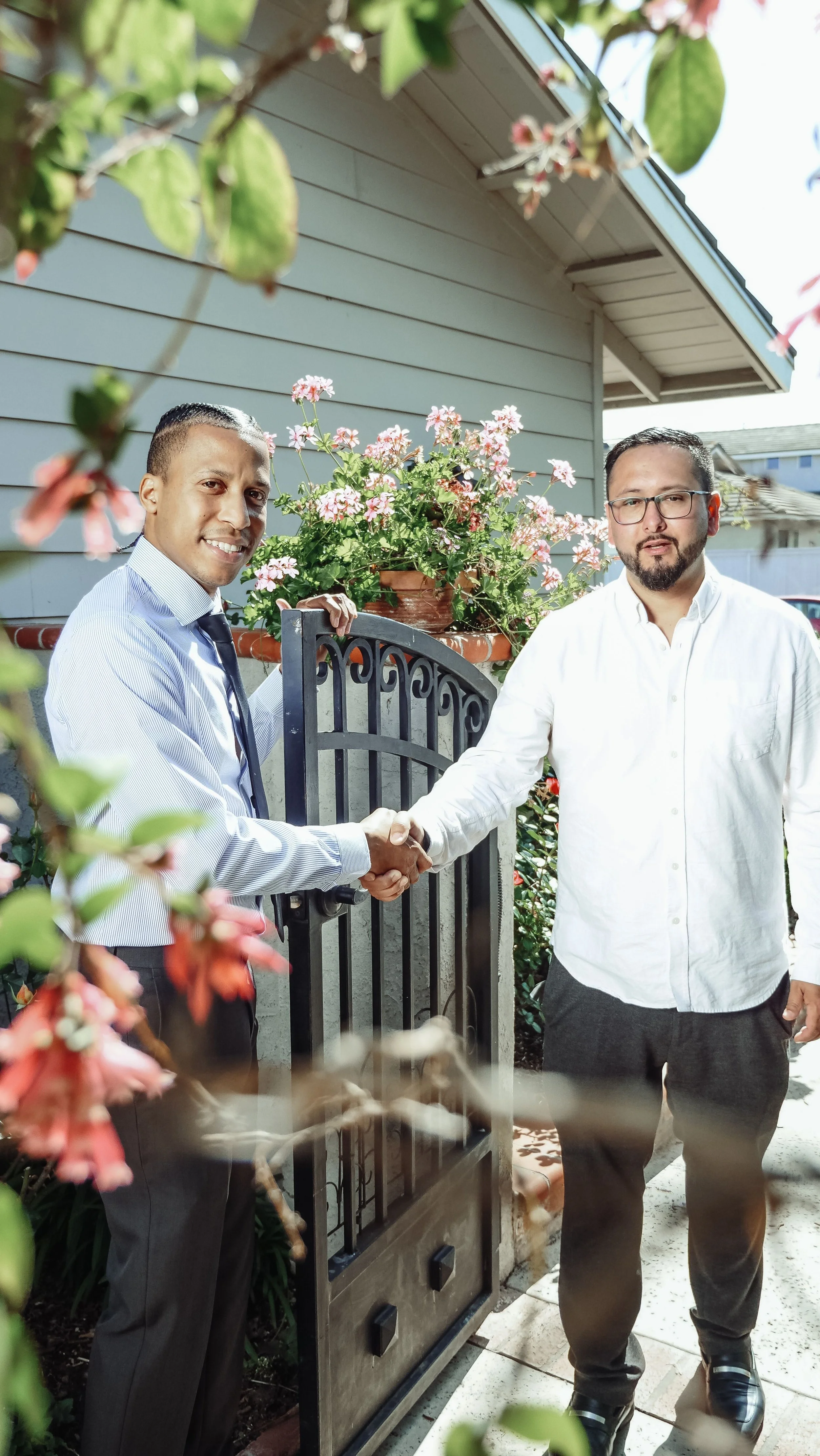 Two neighbors shaking hands after agreeing on a shared fence project