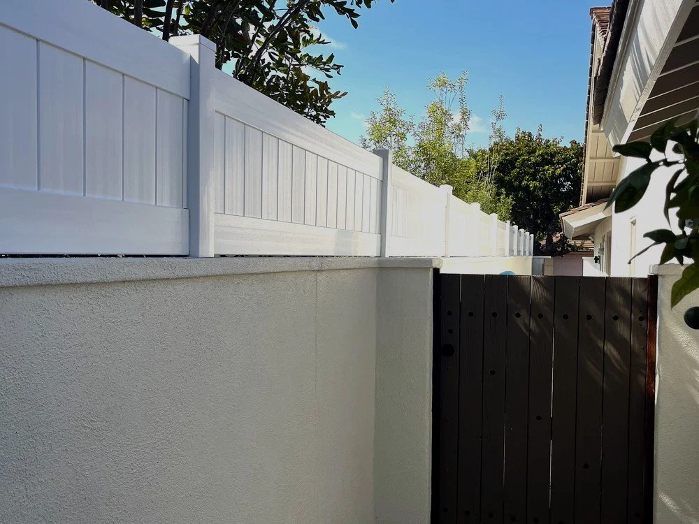 Same stucco wall after adding a white full-privacy vinyl wall topper