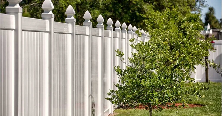 White full privacy vinyl fence panels installed along a backyard