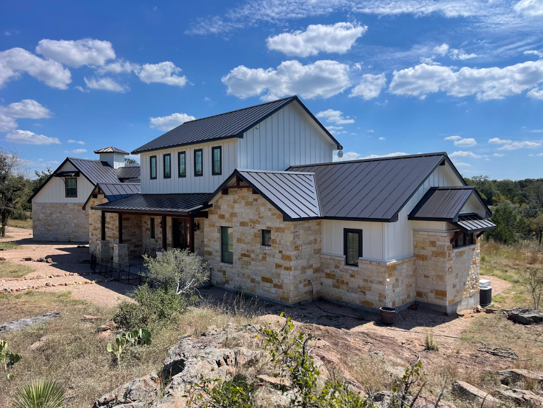Custom-built residential home in the Texas Hill Country, featuring a modern metal roof and natural stone exterior by Owens Contracting LLC in Marble Falls.
