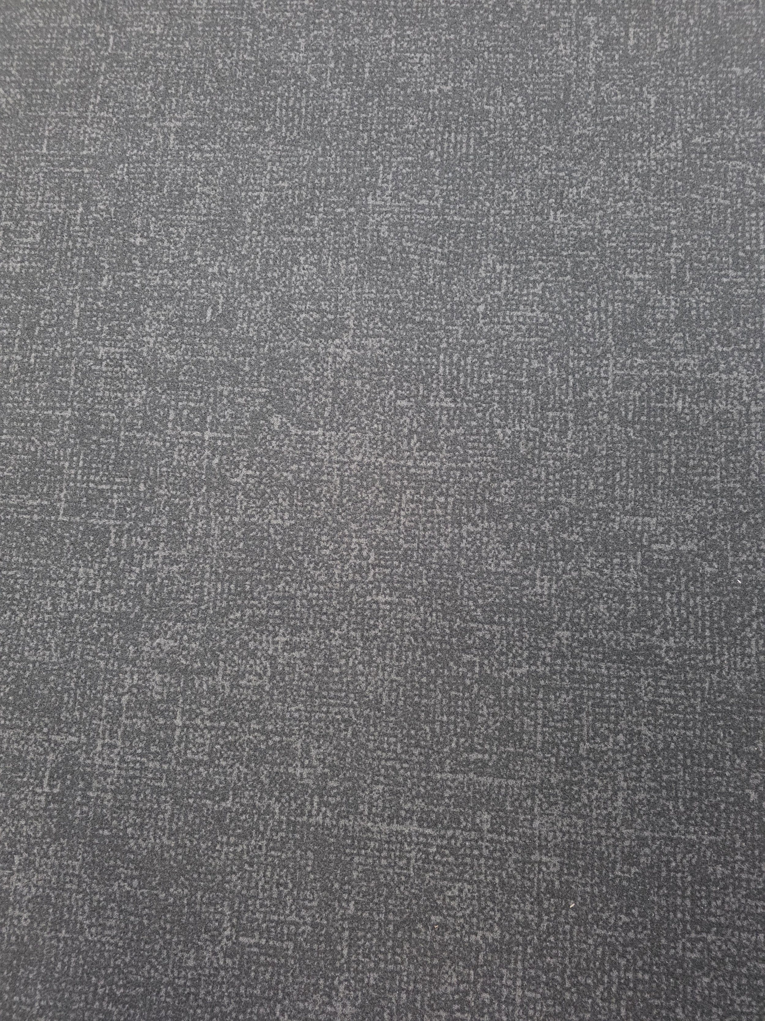 A close-up of a gray, textured carpet with a fine, speckled pattern.