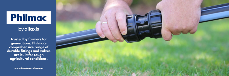 Close-up of a person's hand attaching a hose to a sprinkler nozzle in a grassy yard. The image includes a blue and white graphic with the text 'Philmac by aliaxis' and additional information about the product.