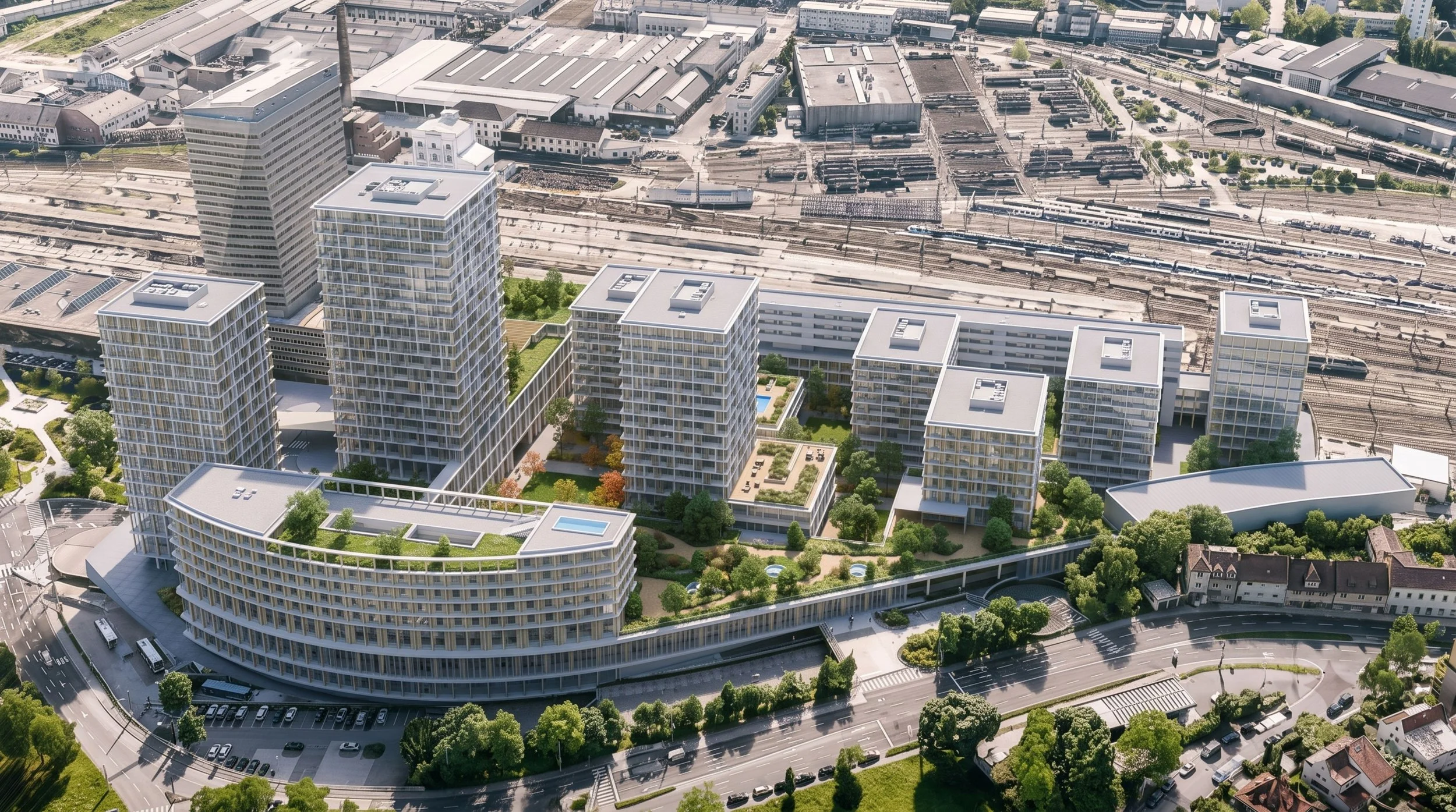 Aerial view of modern high-rise apartment buildings with greenery, rooftop pools, and surrounding roads, train tracks, and industrial area.