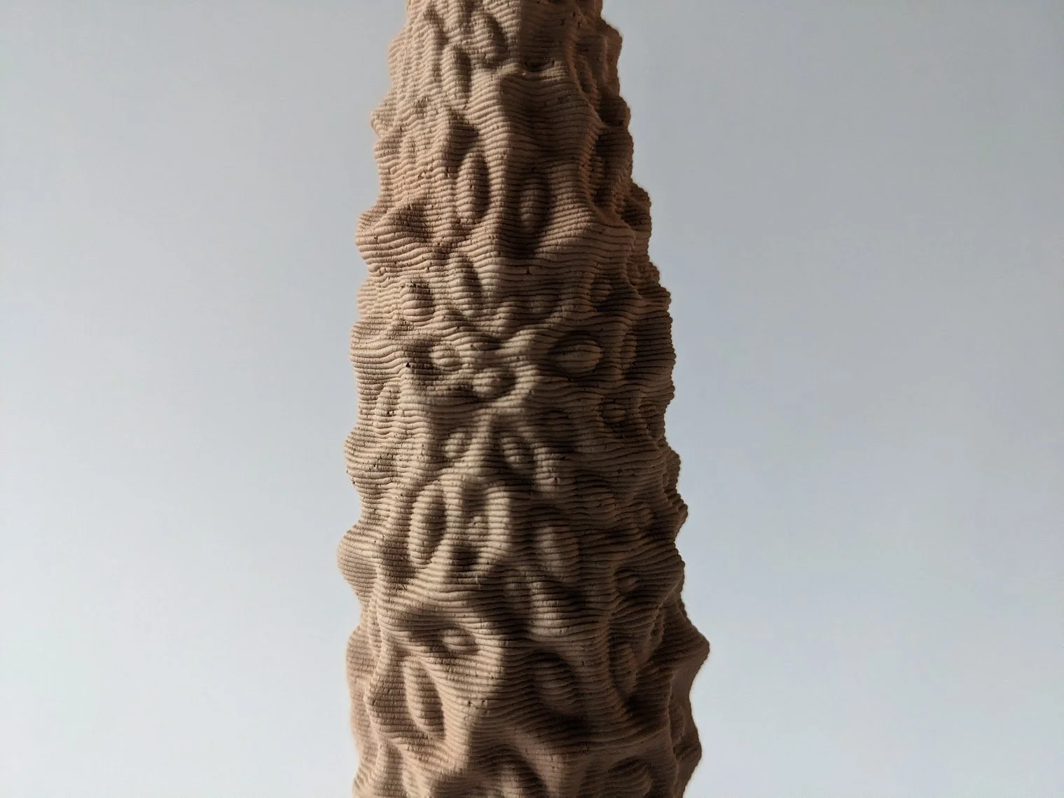 Close-up of a textured, vertically oriented sculpture with intricate patterns and a wavy surface. Made with Grasshopper 3d