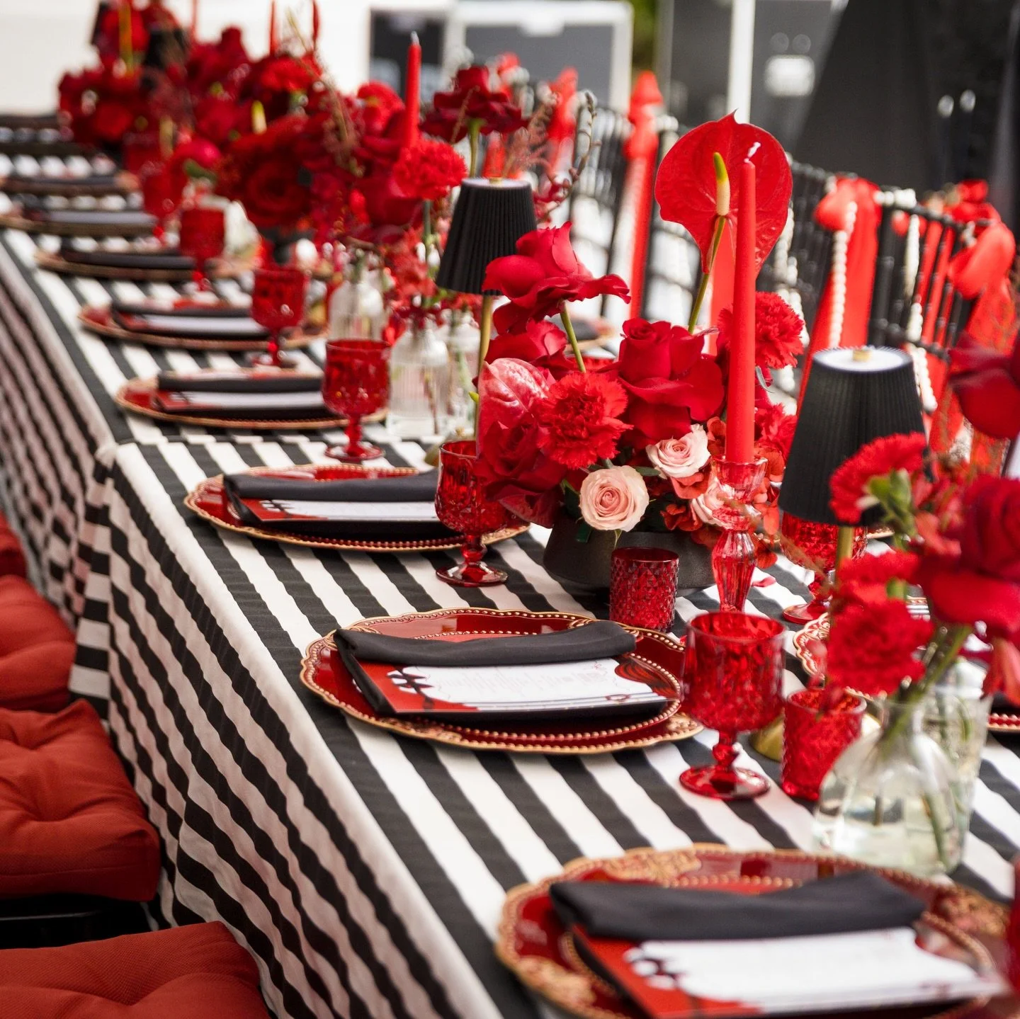 A dazzling 18th birthday celebration inspired by the glitz of Hollywood &mdash; stunning bold red florals, dramatic table accents, touches of gold, cinematic props, and a movie-night experience guests won&rsquo;t forget. From the striped statement ta