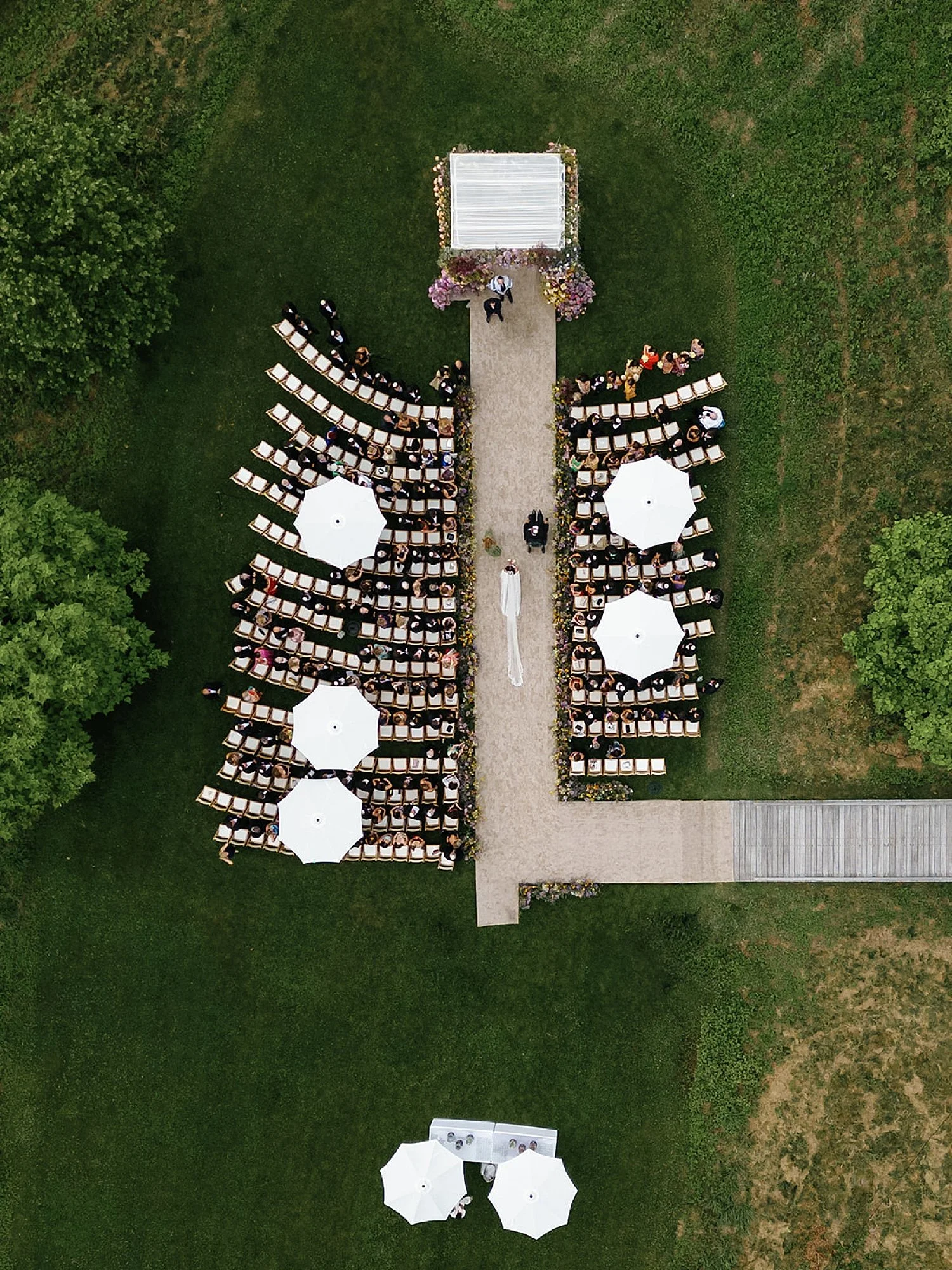  aerial view of wedding ceremony as bride walks down the aisle  