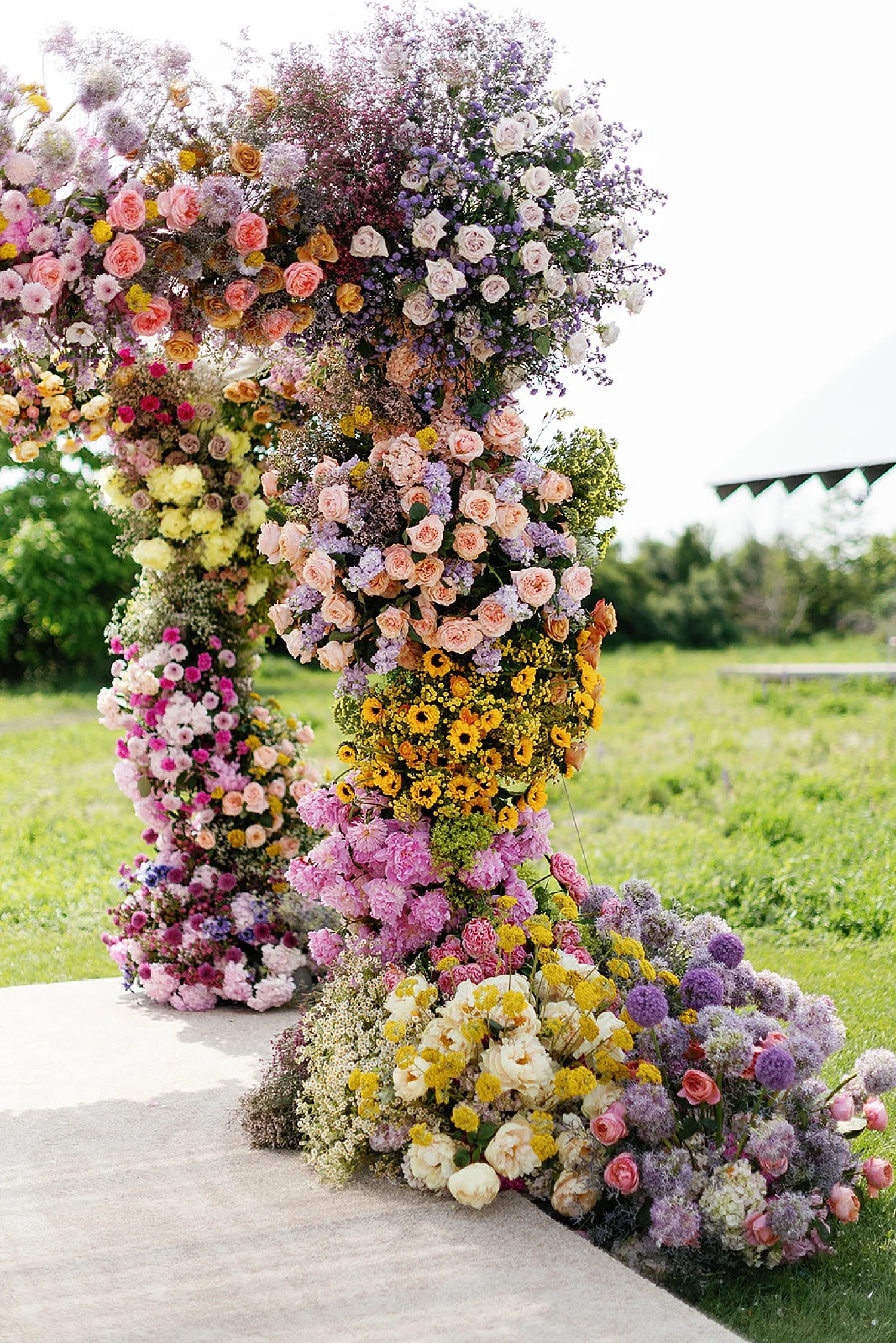  colorful summer flowers decorate chuppah and line the aisle at ceremony  