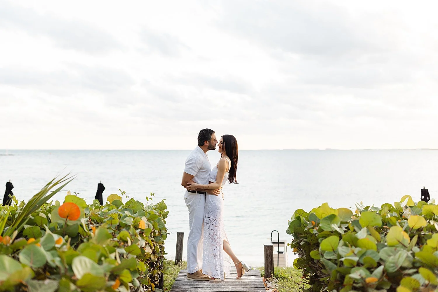  couple embrace by the water in Mexico at resort where they are hosting destination Mexico wedding  