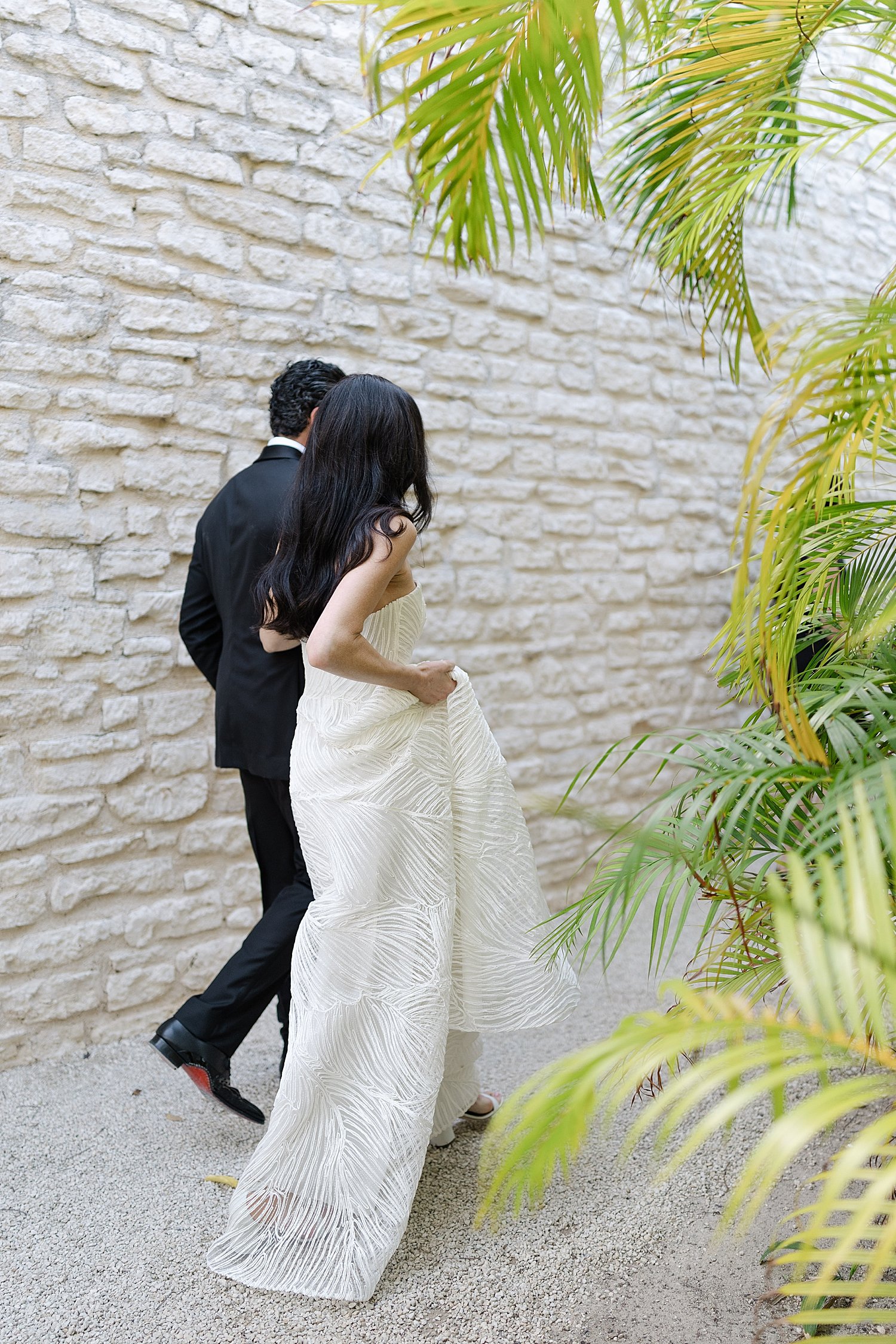  couple walk down path at Destination Wedding at NIZUC Resort in Mexico 